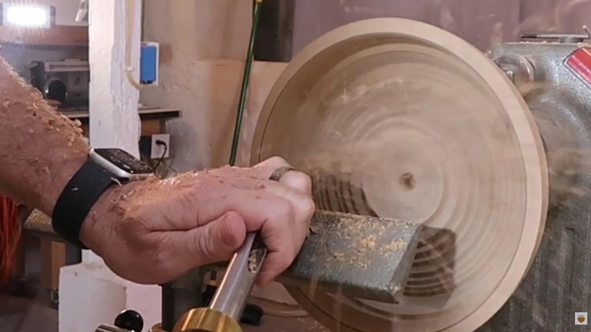 Bowl gouge making a light finishing cut inside a wood bowl.