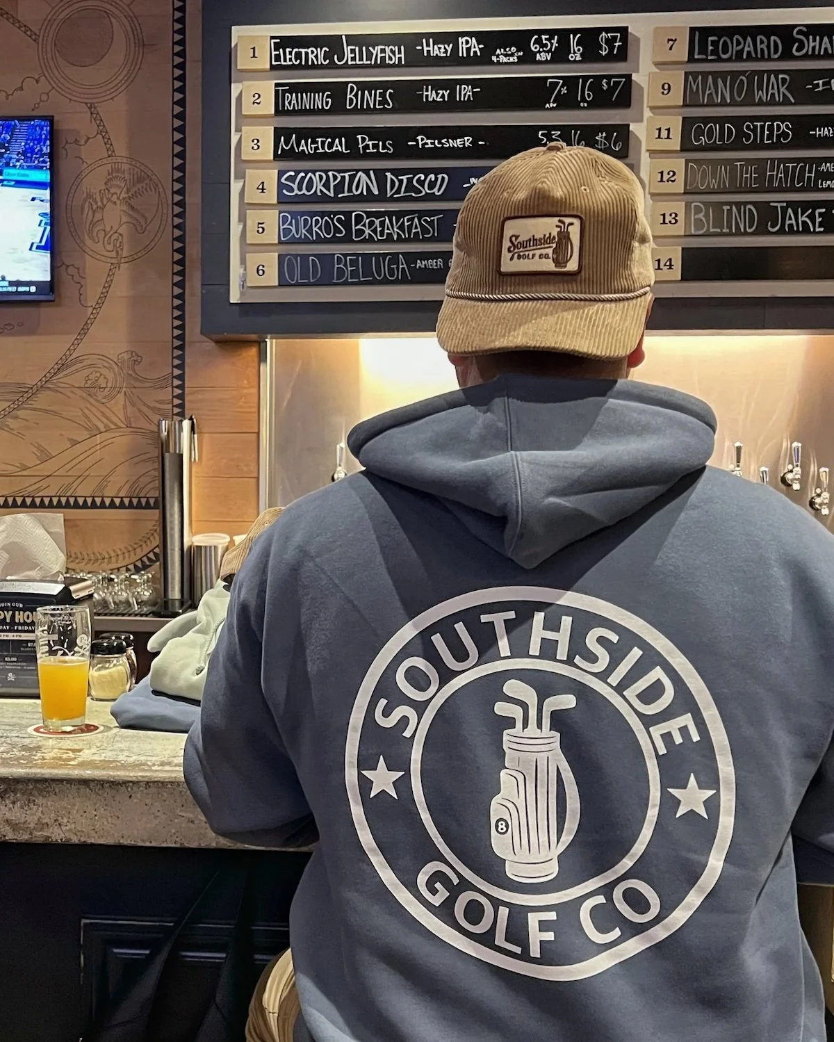 Southside Golf Co hoodie worn in Austin bar featuring logo on back