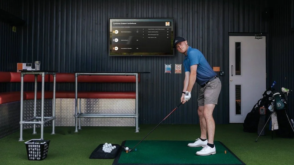 Golfer practicing in a private indoor golf simulator bay in South Austin using TrackMan technology