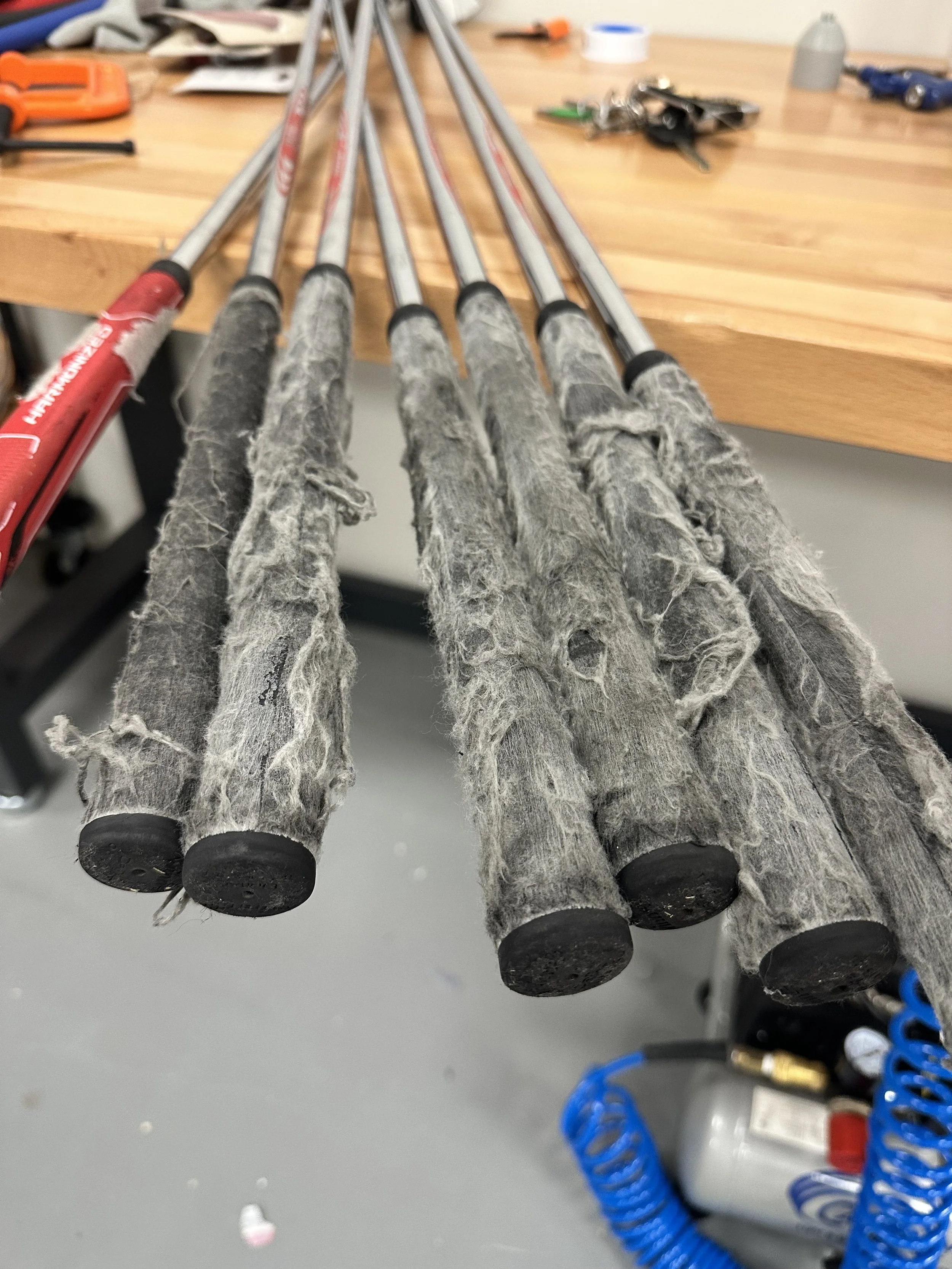 Worn golf grips before professional golf club regripping at Southside Golf Co in South Austin.