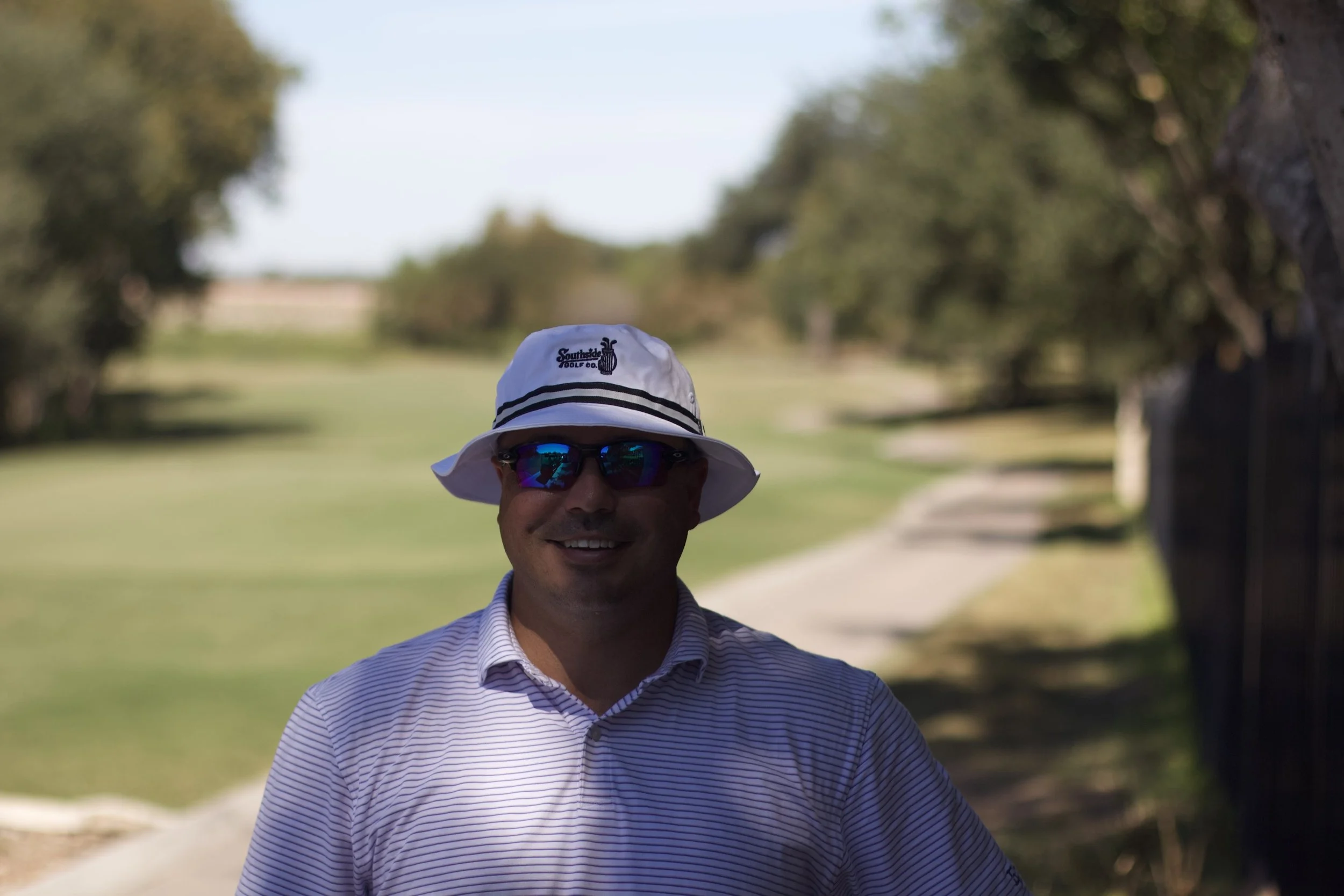 Justin Aragon, PGA, wearing a Southside Golf Co hat on an Austin golf course