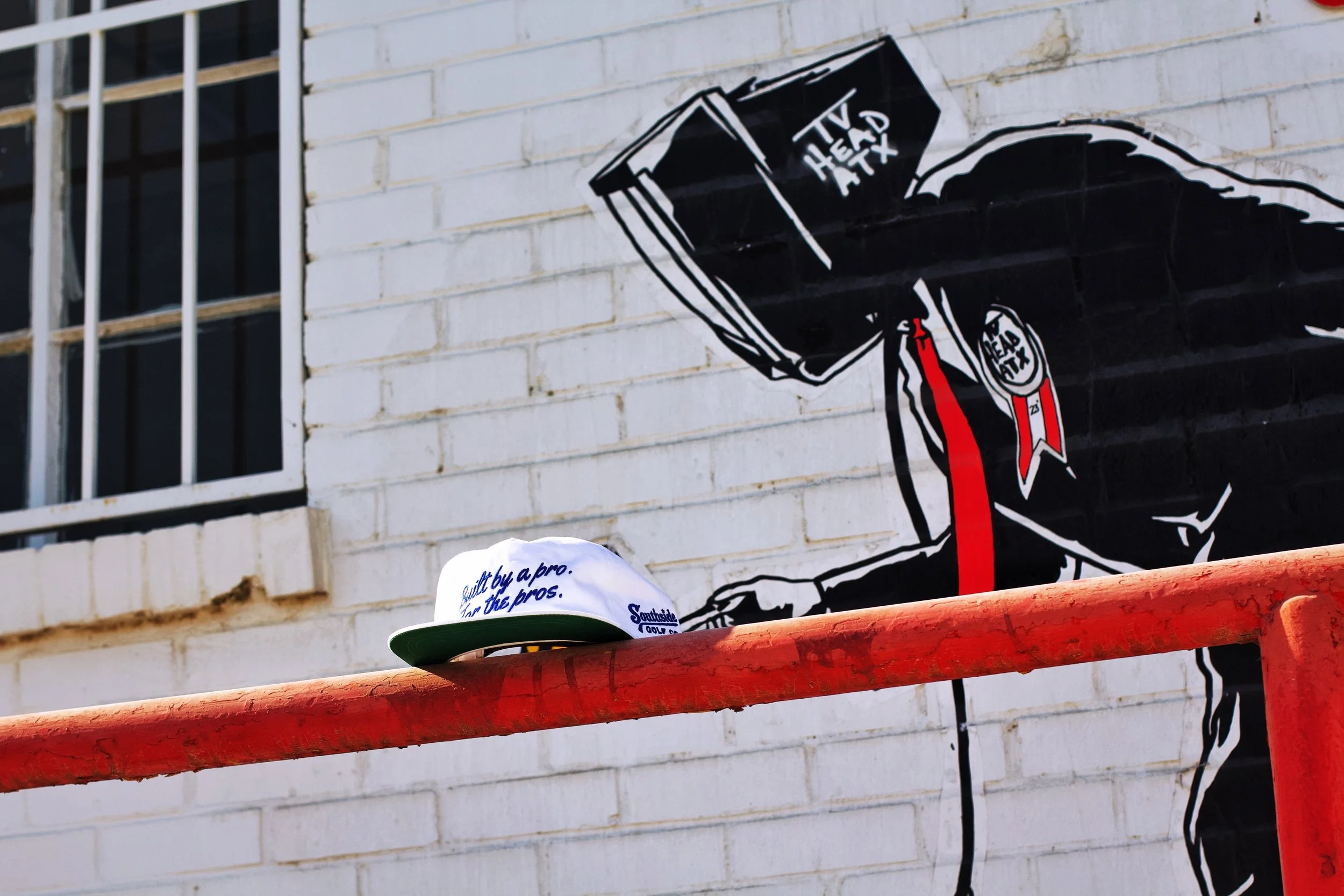 Southside Golf Co white snapback hat styled in South Austin with street mural background
