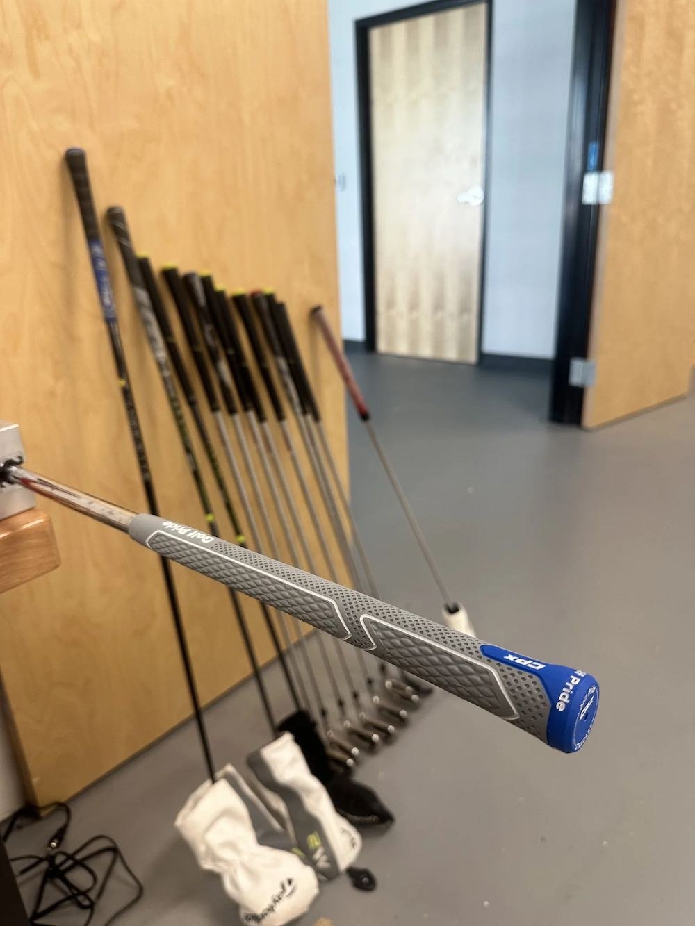 Golf clubs on a rack after being freshly regripped at Southside Golf Co.