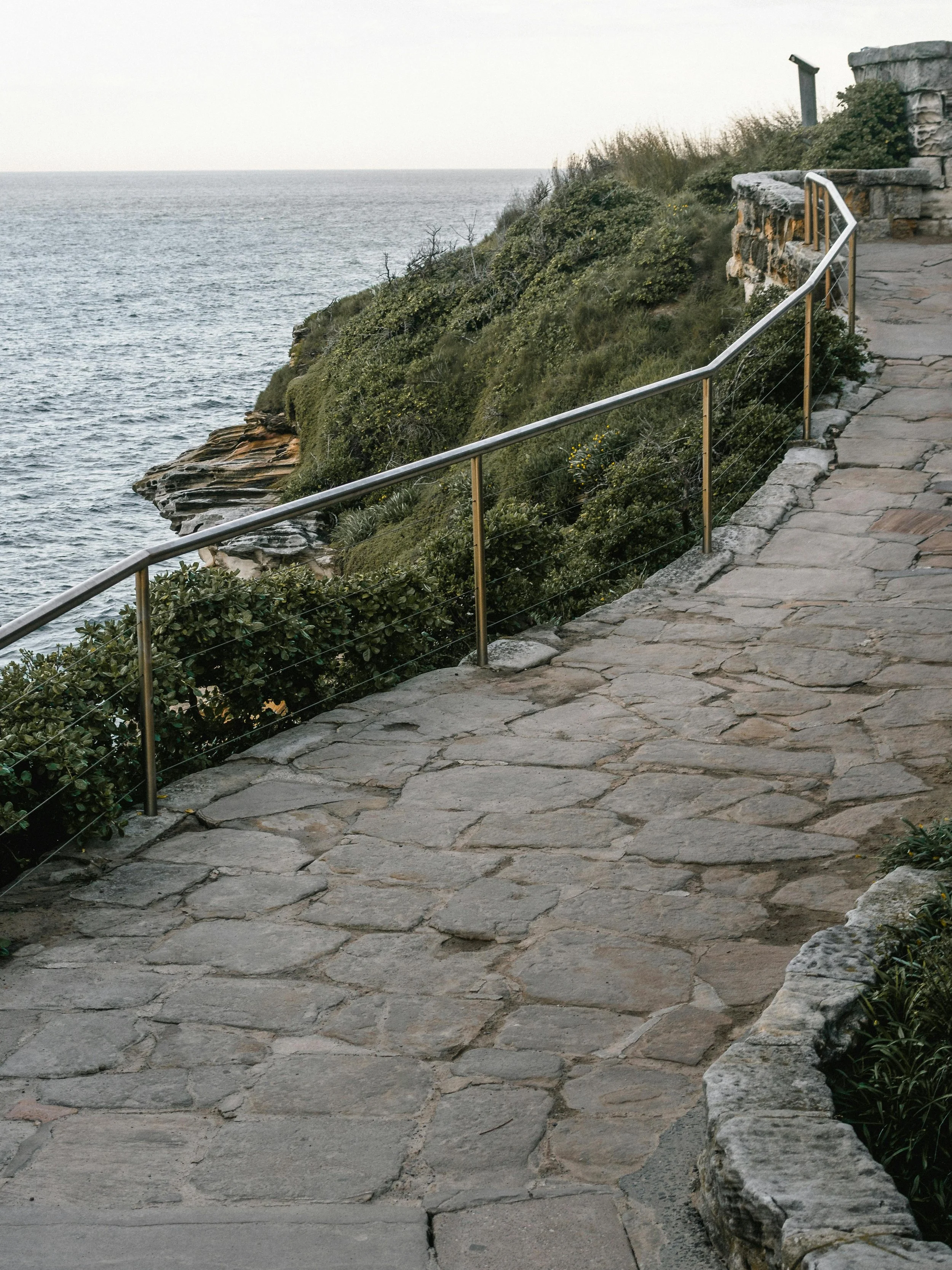 A stone pathway along a cliff overlooking the ocean, representing the journey of Attio CRM for customers