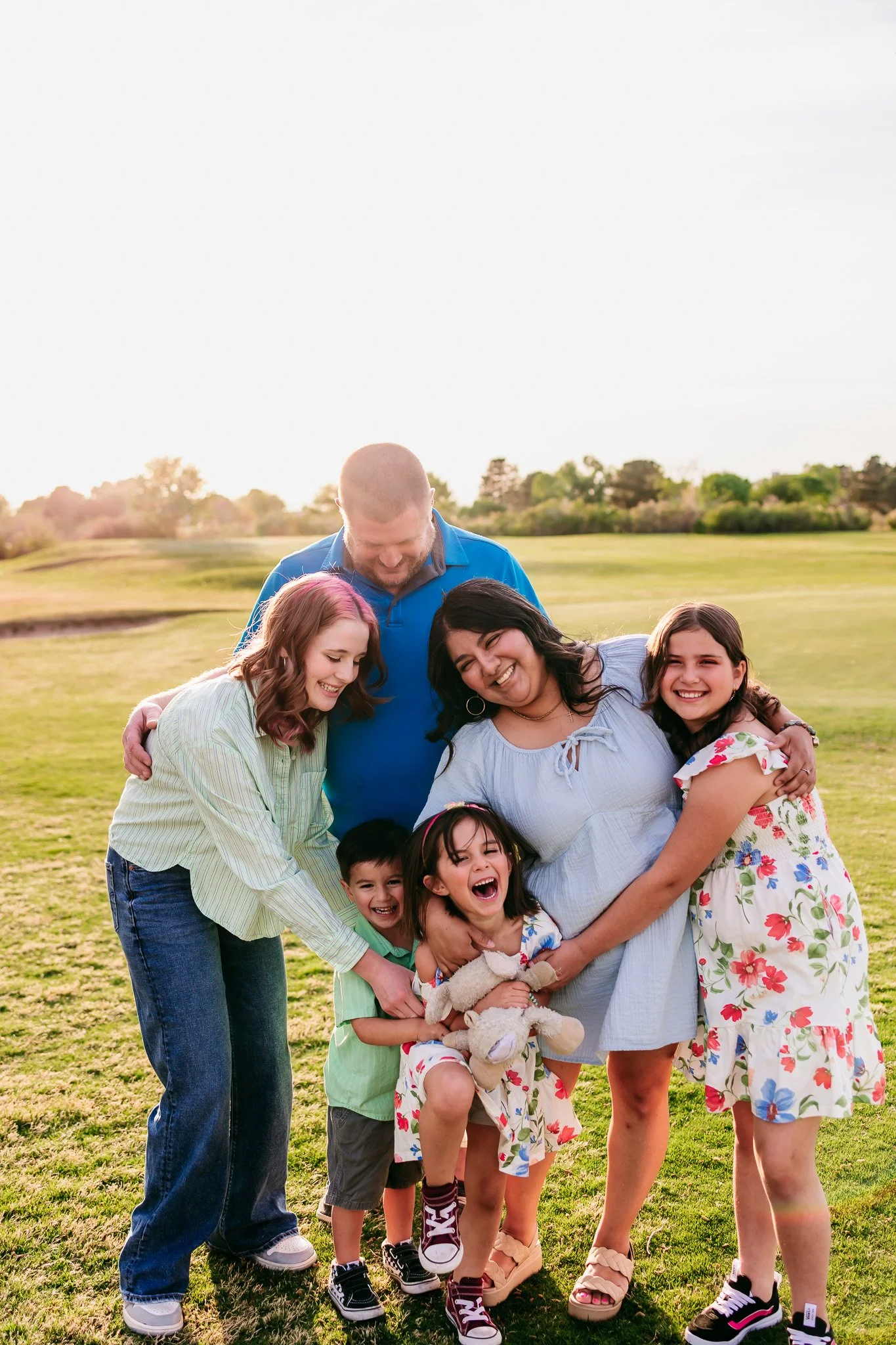 Family gathered together for a playful group portrait during a sunset family photography session in Las Cruces, New Mexico.