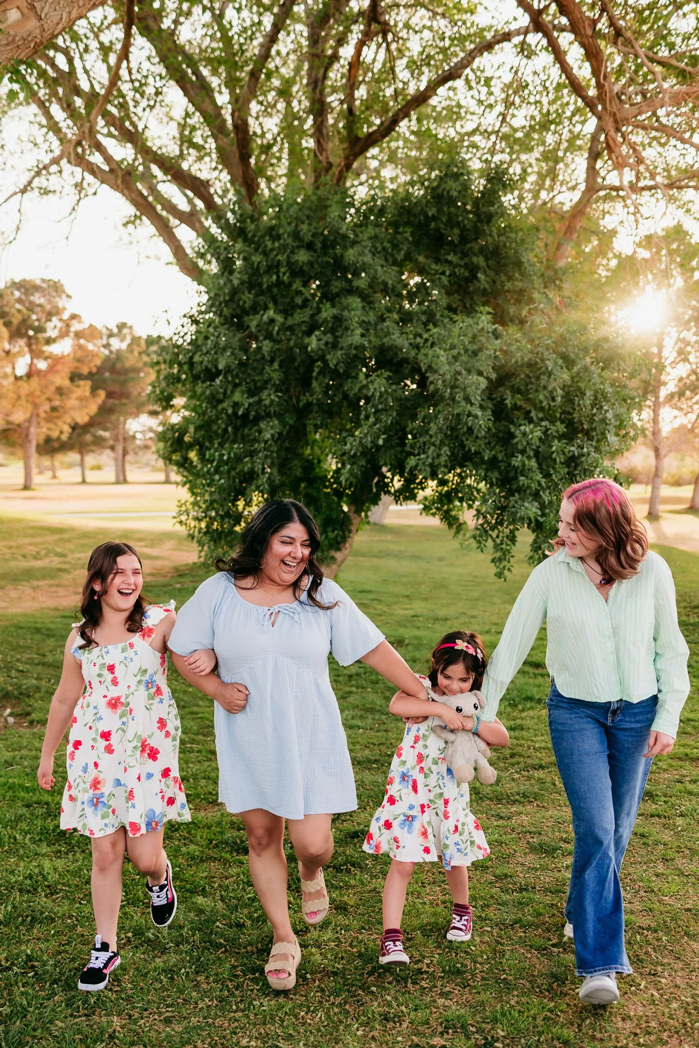 Mother walking hand in hand with her daughters during a candid family photography session in Las Cruces, New Mexico.
