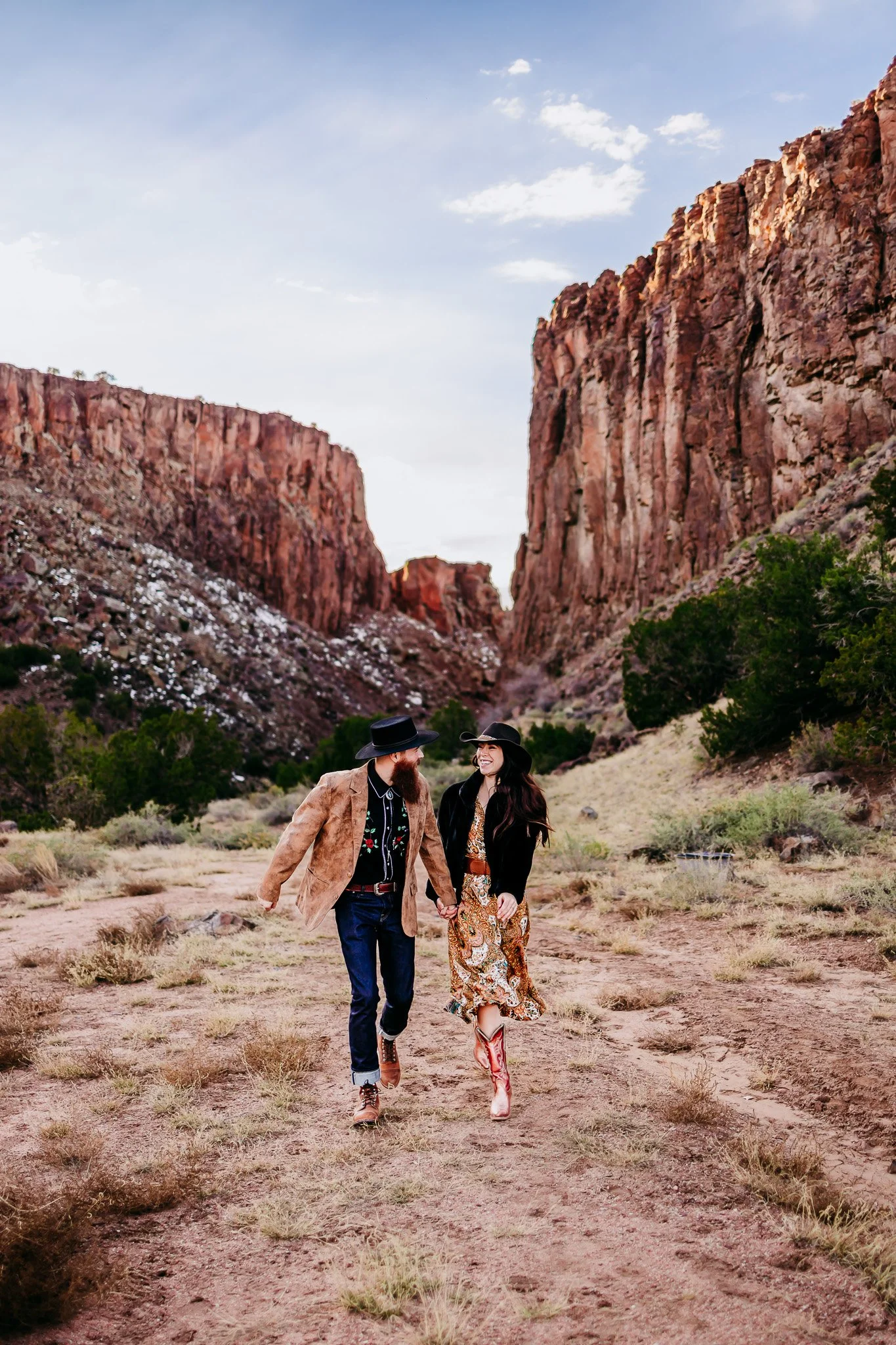 Partners walking hand in hand through Diablo Canyon during an adventurous couples photography session in northern New Mexico.