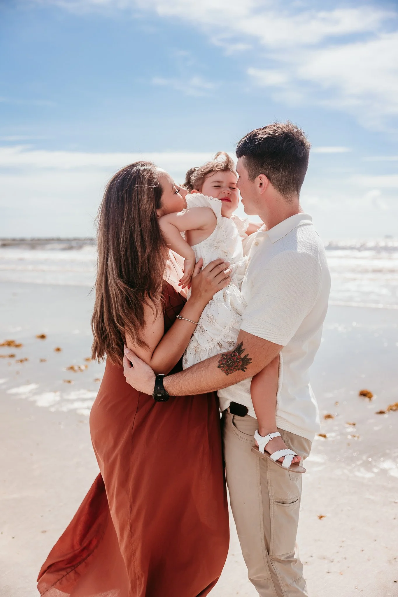 Family sharing a hug on Jacksonville Beach during a sunset maternity and family photography session in Florida.