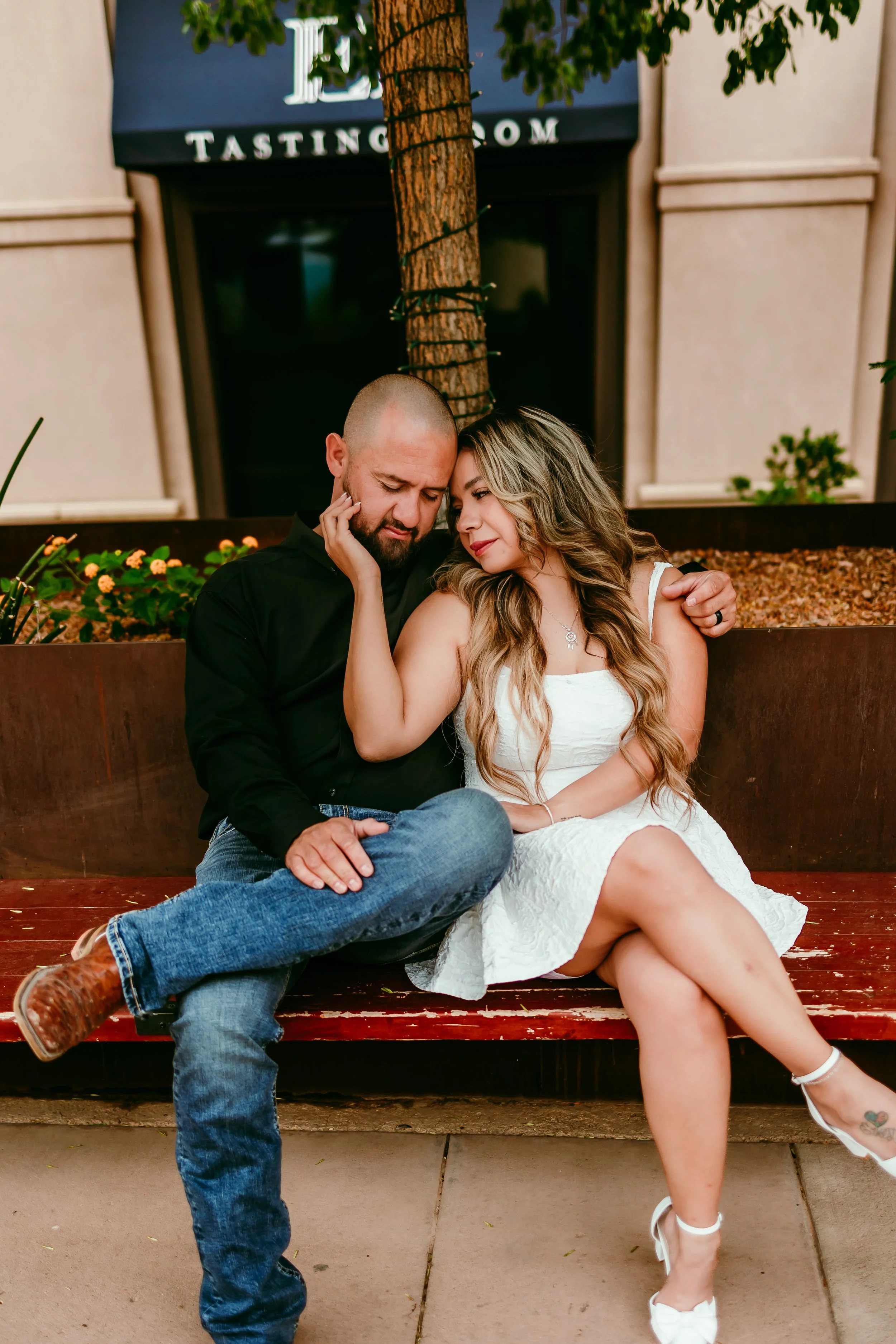 Couple sitting together and smiling during an urban engagement photography session in downtown El Paso, Texas.