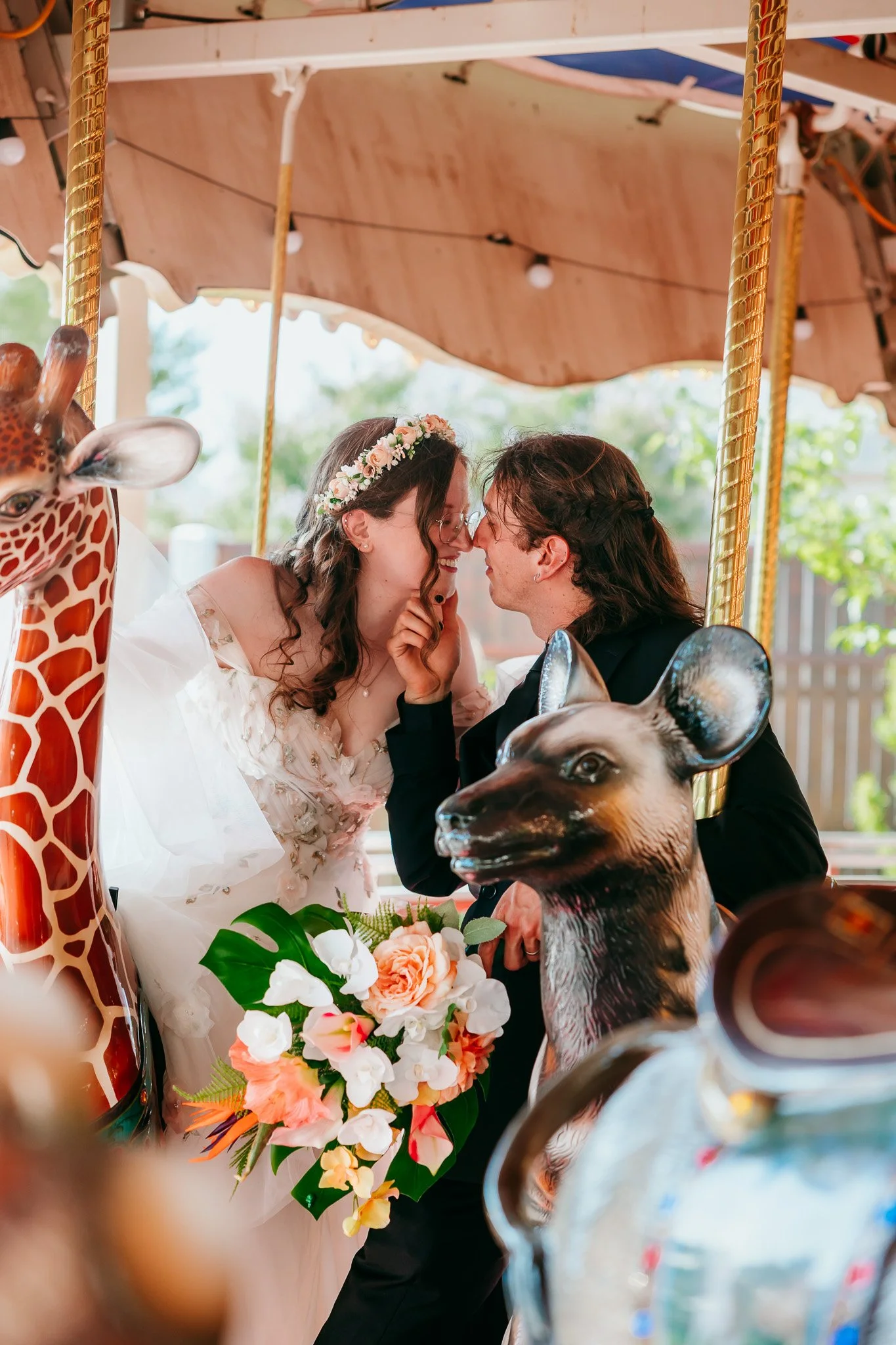 Newlywed couple sharing a candid romantic embrace on the carousel during their wedding at the El Paso Zoo in El Paso, Texas
