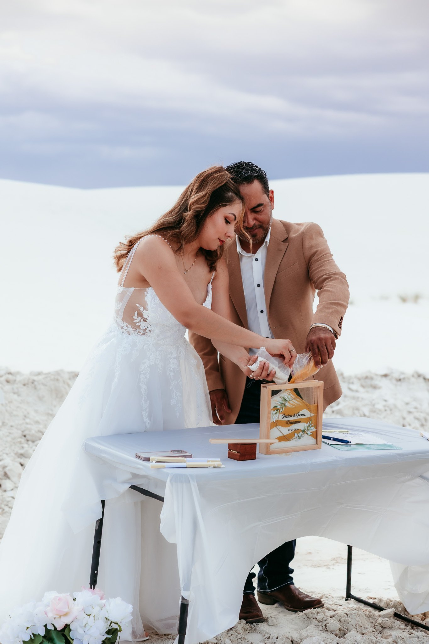 Couple pouring sand during their unity ceremony at White Sands National Park in New Mexico.