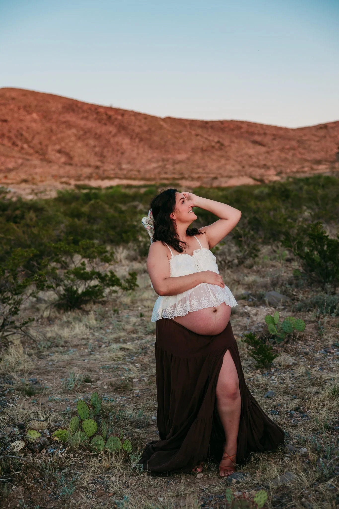 Lifestyle maternity photography featuring an expecting mother enjoying a sunset maternity session in the El Paso mountains.