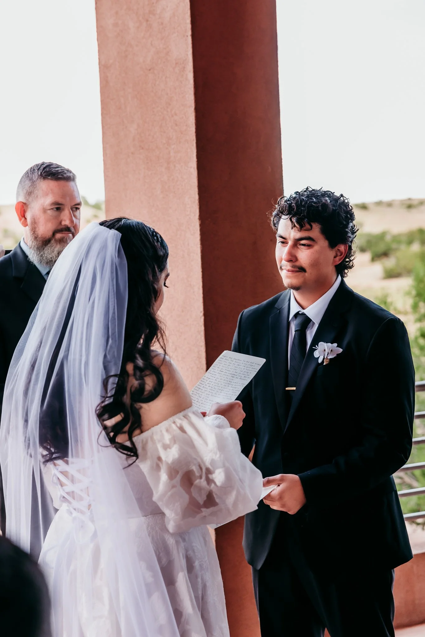 Bride reading handwritten vows to her groom during their intimate elopement ceremony overlooking Abiquiu Lake in northern New Mexico.