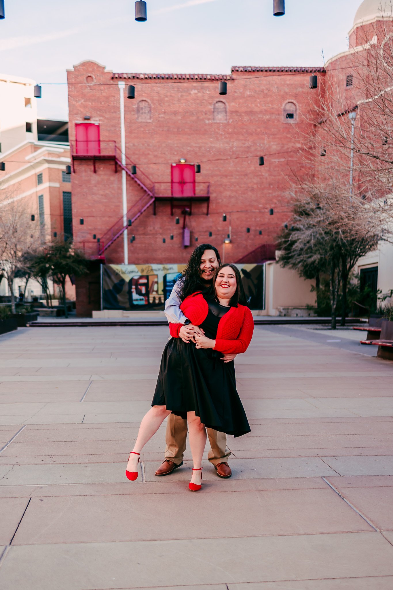 Engaged couple embracing in the heart of downtown El Paso during a romantic couples photography session.