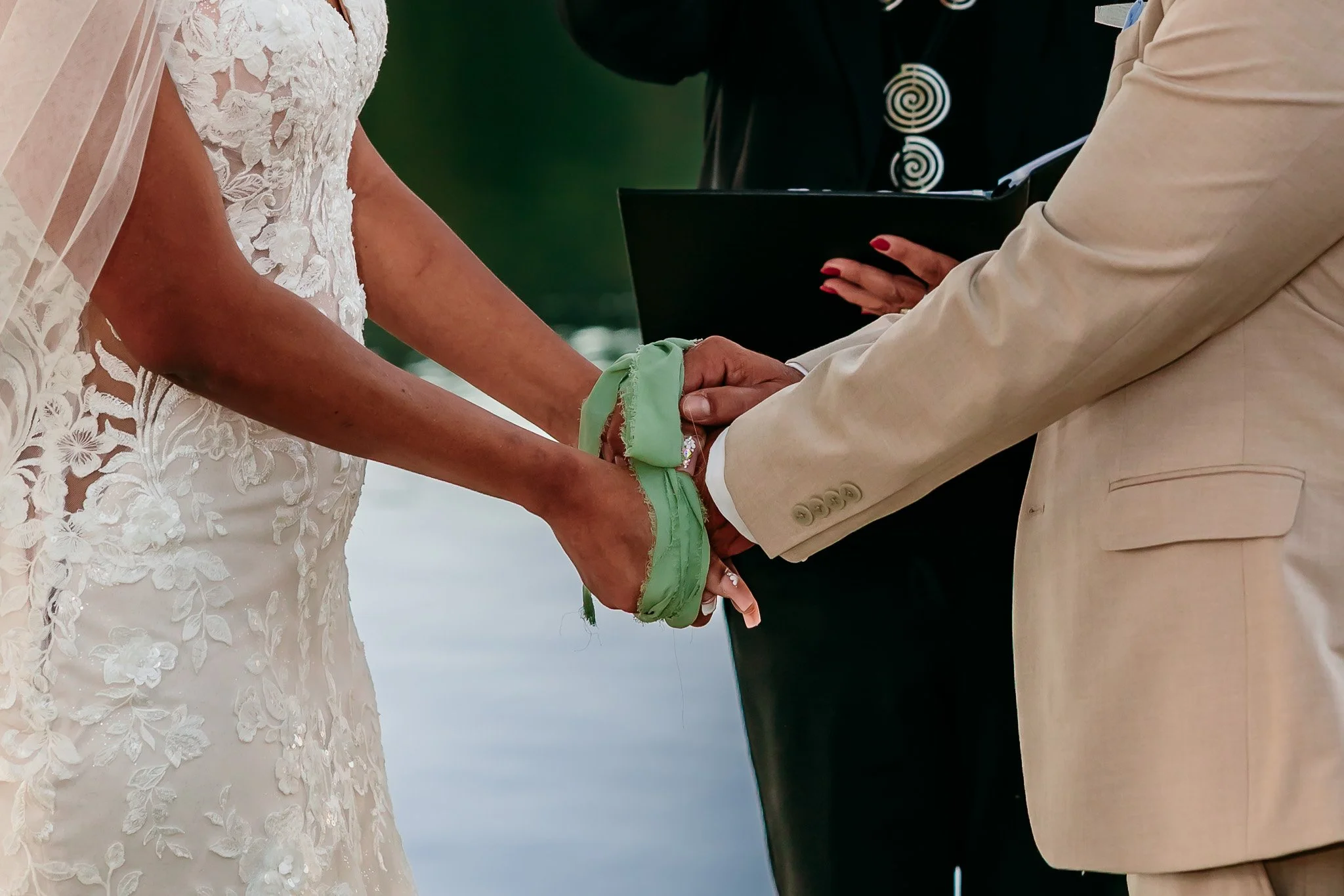 Bride and groom participating in a handfasting ceremony during their intimate lakeside wedding at Inn of the Mountain Gods in Ruidoso, New Mexico.