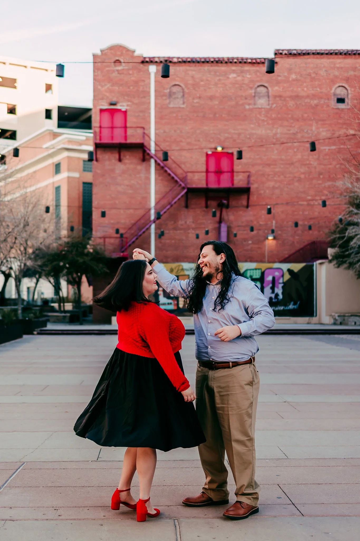 Couple dancing together in downtown El Paso during a playful engagement photography session in Texas.