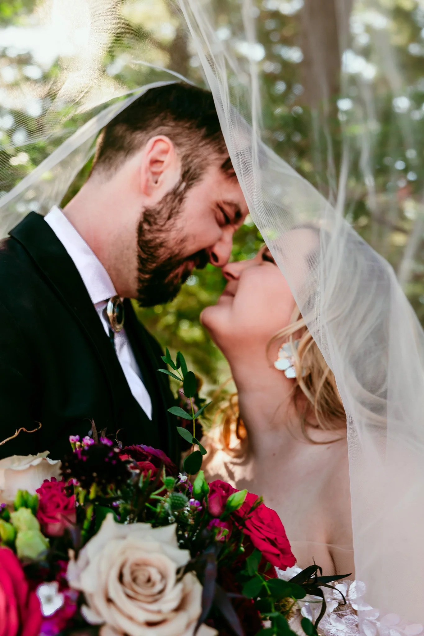 Bride and groom sharing an intimate moment beneath the wedding veil during their mountain wedding at The Lodge Resort in Cloudcroft, New Mexico.