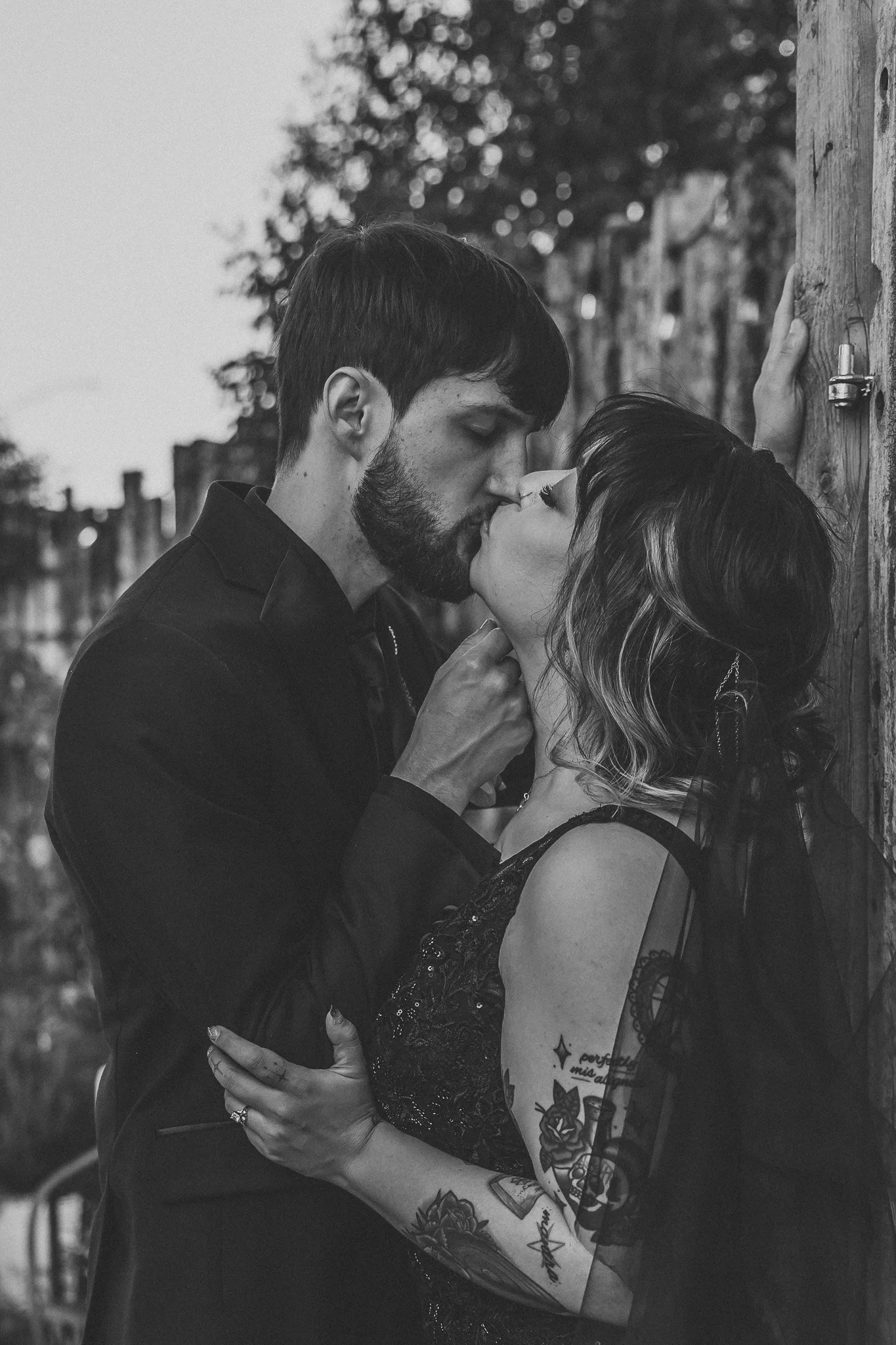 Close-up of the bride and groom kissing beside a rustic wooden doorway at The Mystic in Santa Fe, New Mexico.