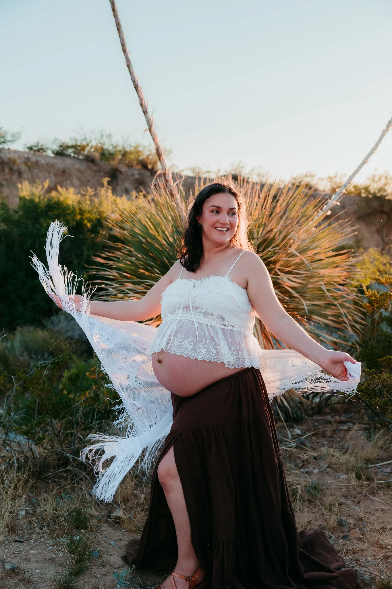 Expecting mother twirling her dress during a beautiful sunset maternity session in the El Paso mountains.