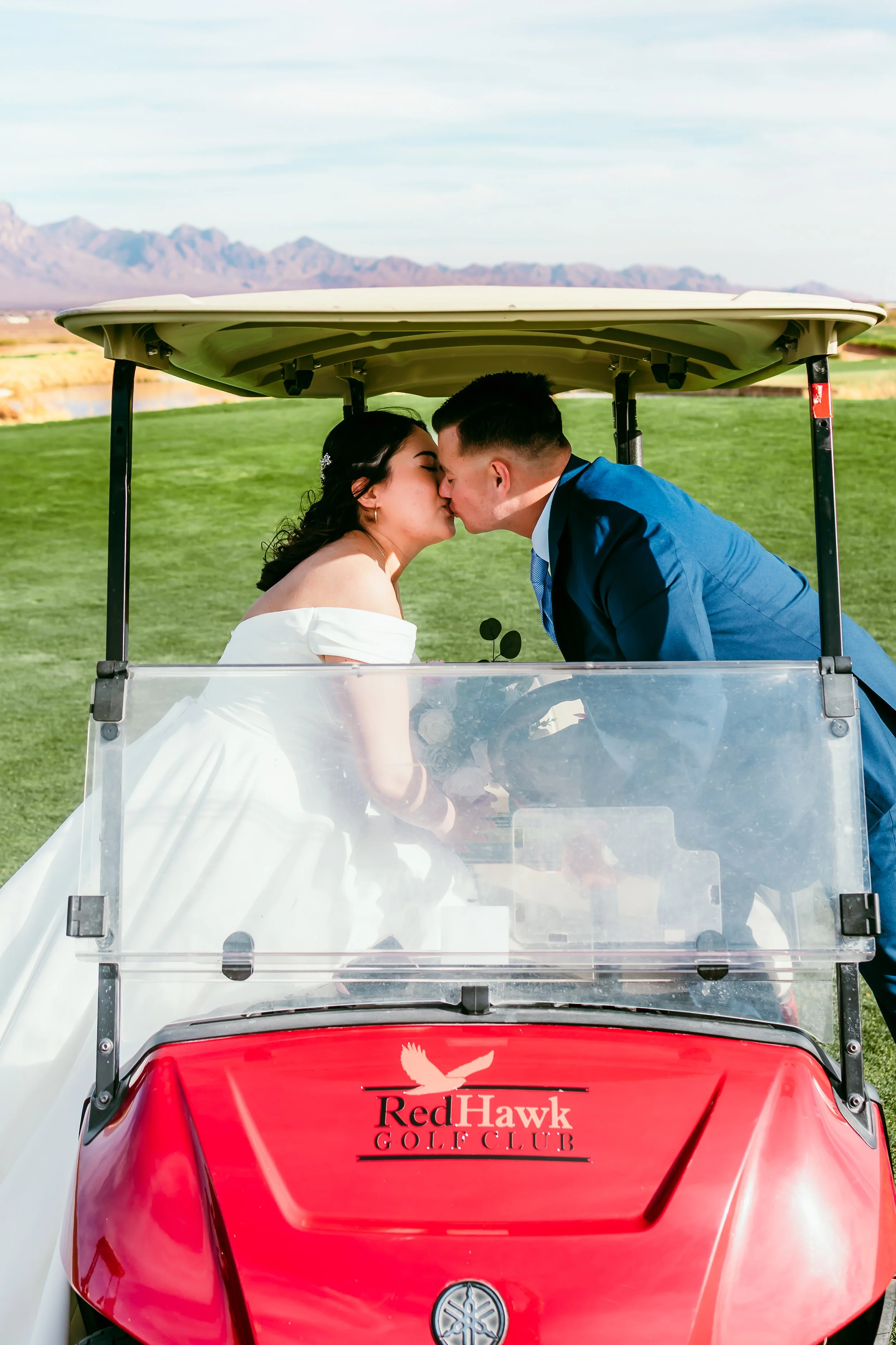 Newly married couple sharing a kiss inside a golf cart at Red Hawk Golf Club in Las Cruces, New Mexico.