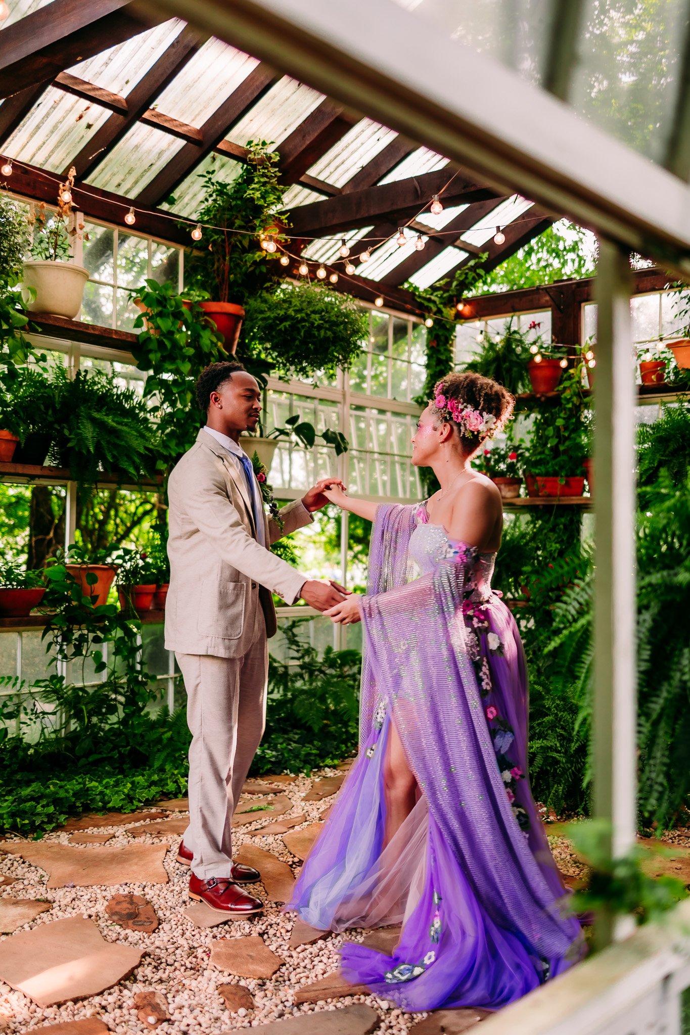 Newlywed couple holding hands in the greenhouse during their colorful elopement at The Vaughn House in Forest, Virginia.