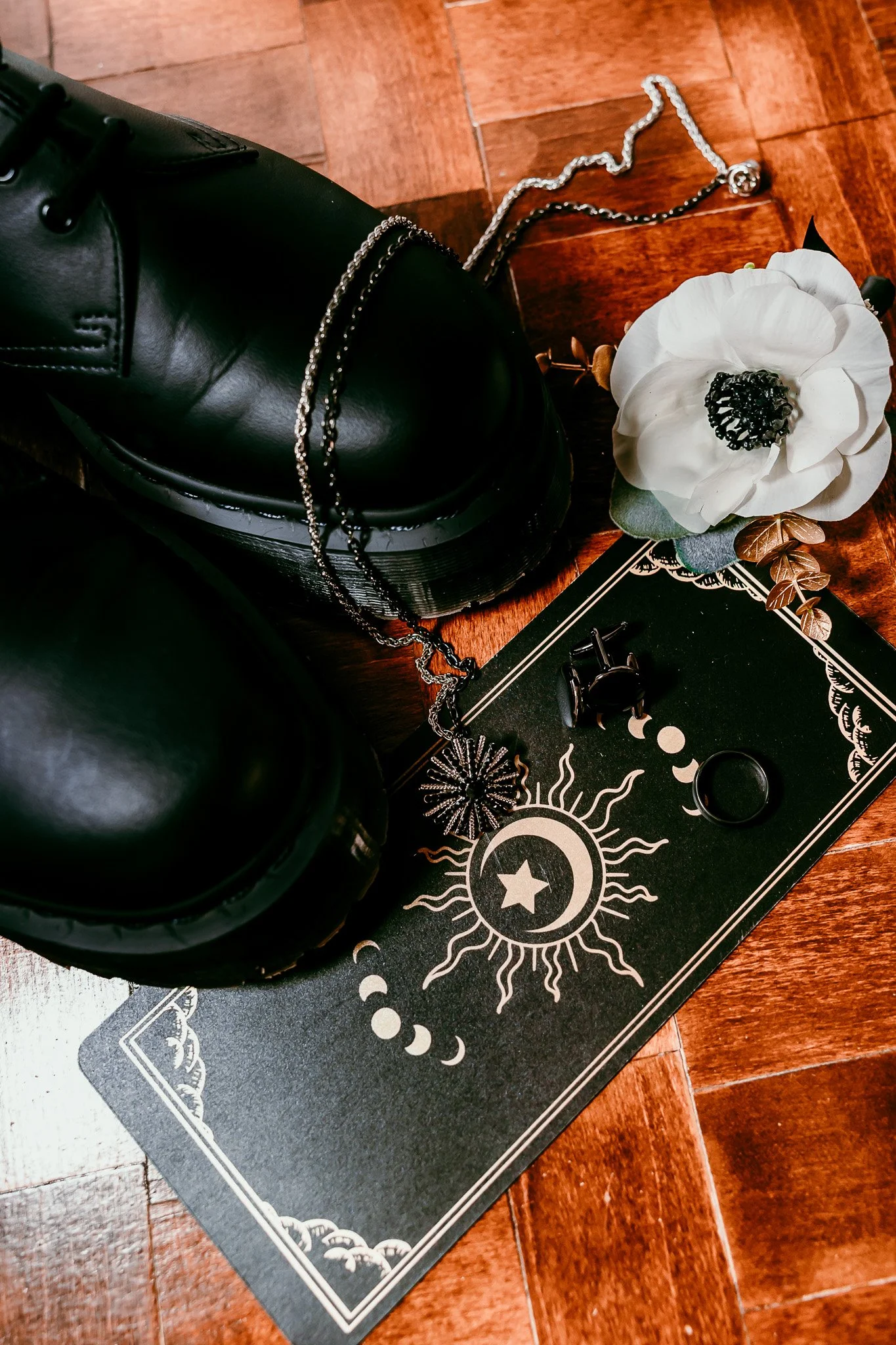 Groom's wedding details with black boots, boutonniere, wedding rings, cufflinks, and celestial invitation suite for an intimate Santa Fe wedding.