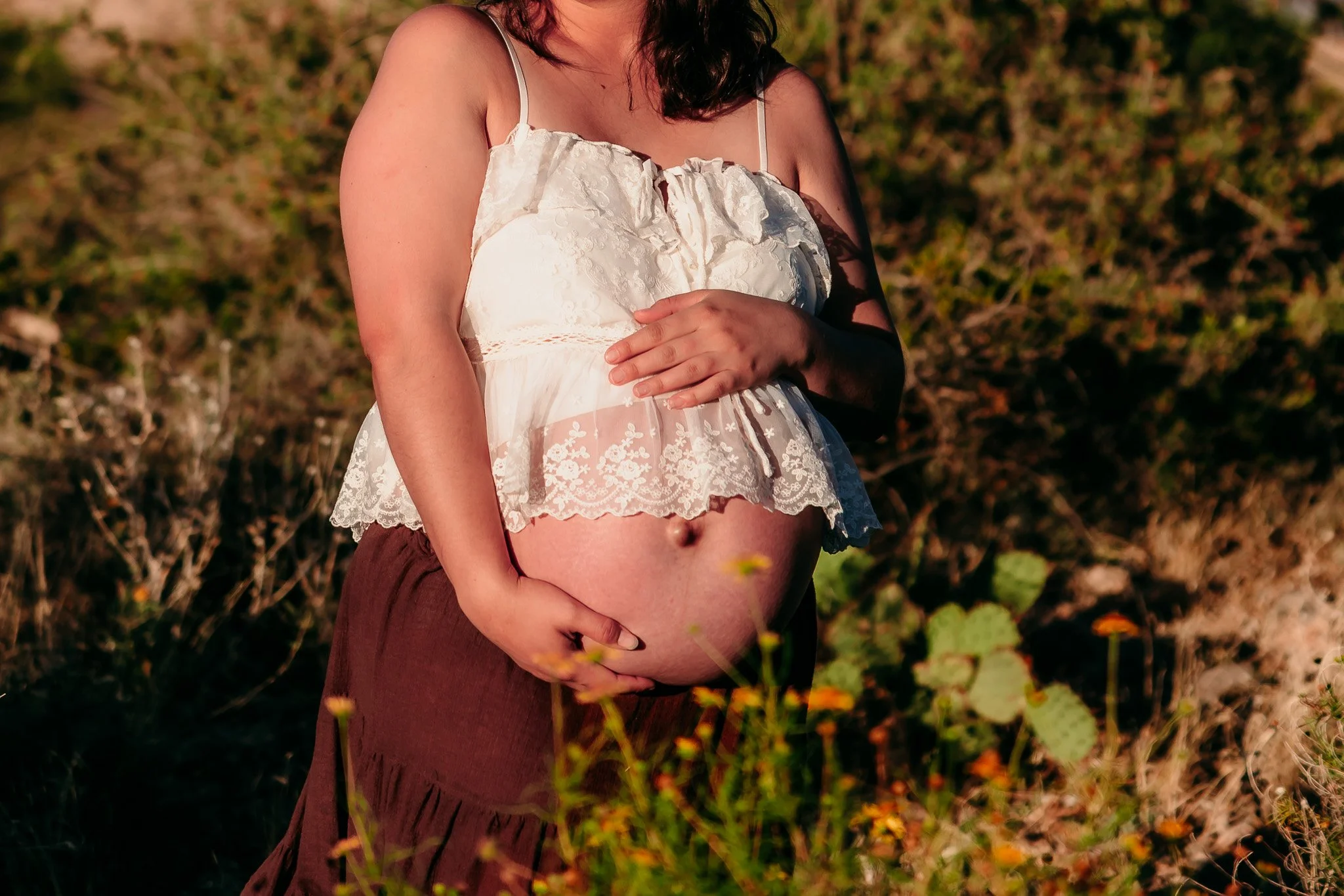 Close-up of a growing baby bump during a natural outdoor maternity photography session in the El Paso mountains.
