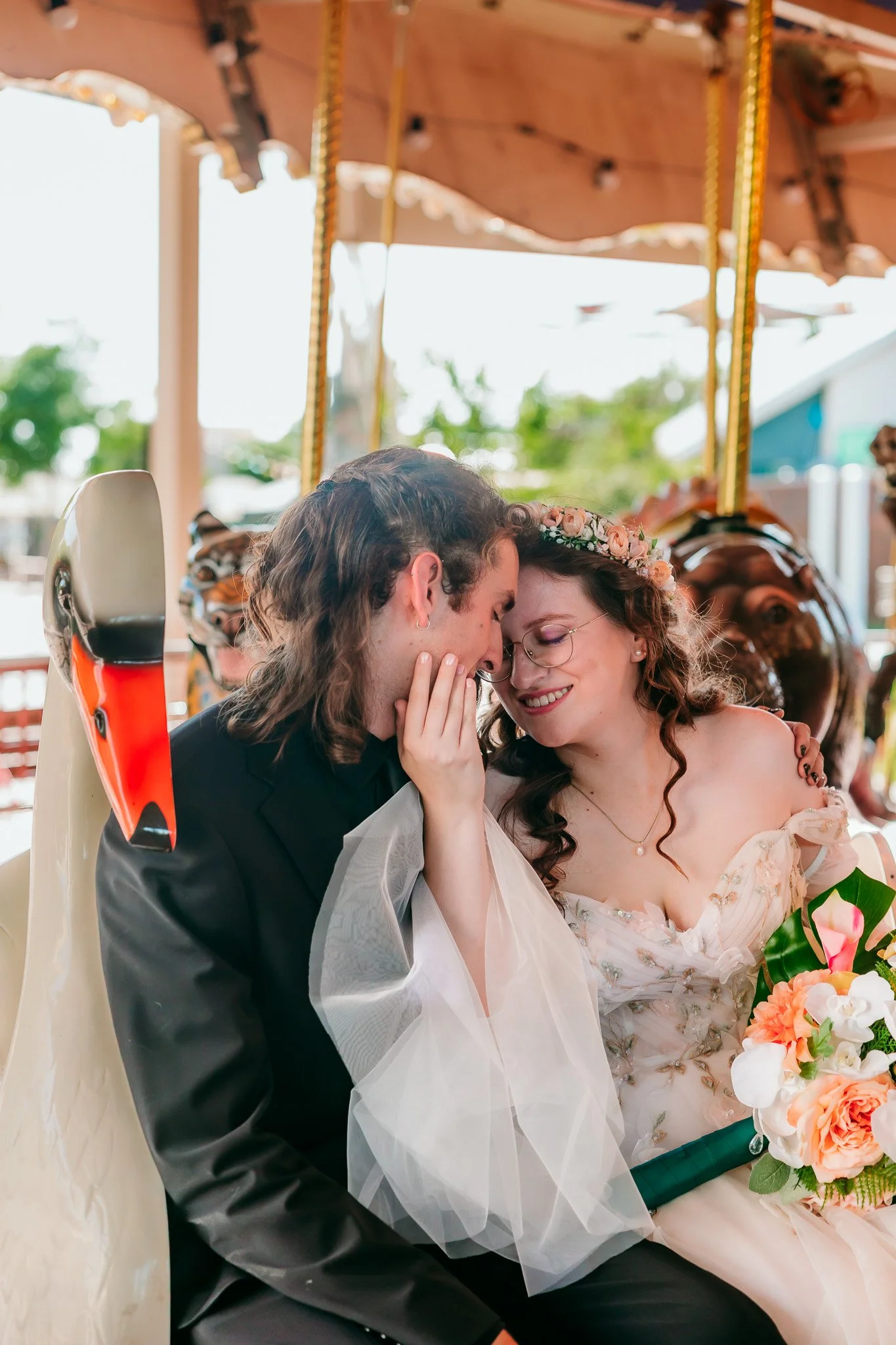 Bride and groom sitting on the swan bench at the carousel during their wedding at the El Paso Zoo in El Paso, Texas.