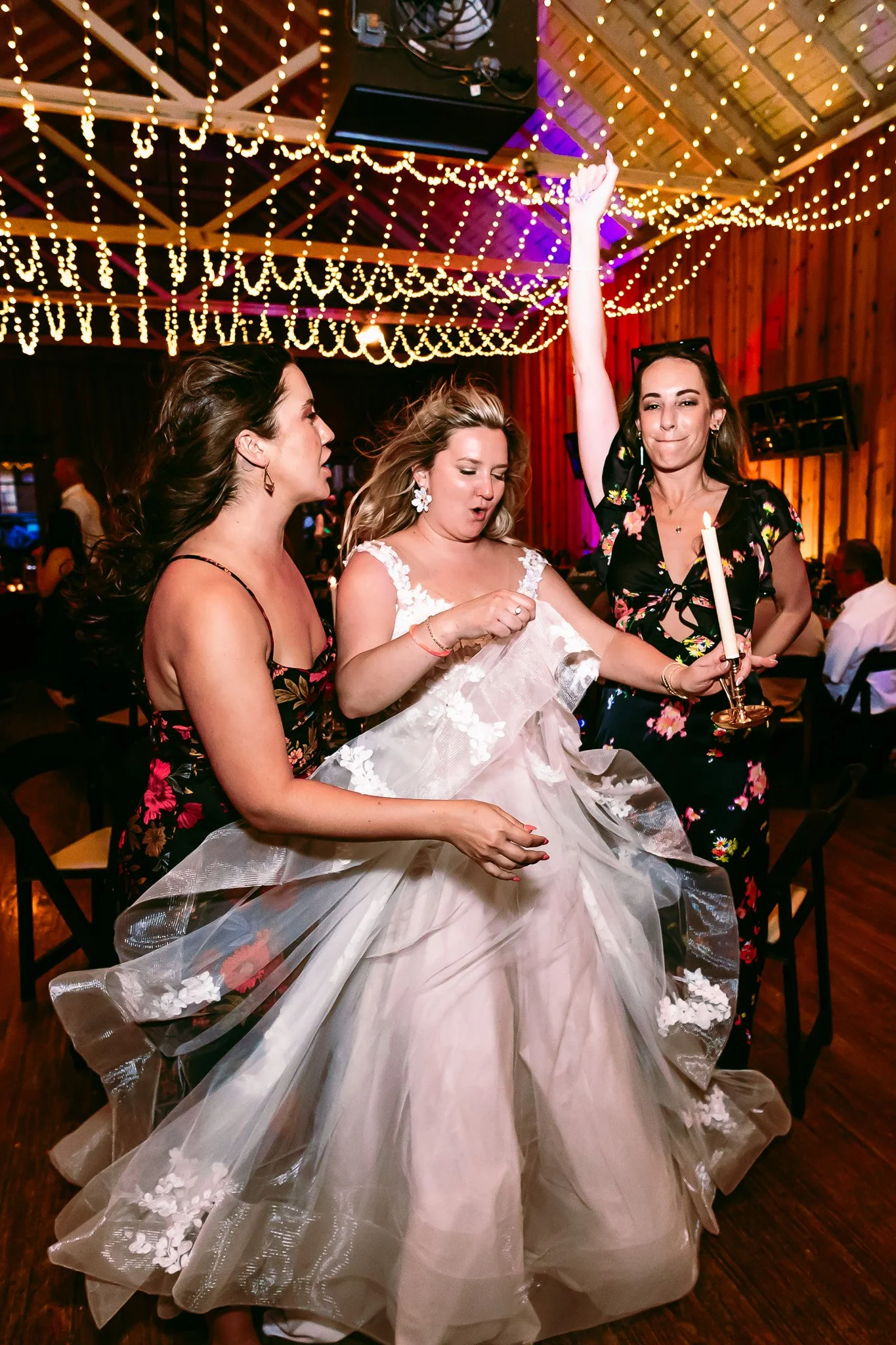 Bride dancing with friends beneath string lights during the wedding reception at The Lodge Resort in Cloudcroft, New Mexico.
