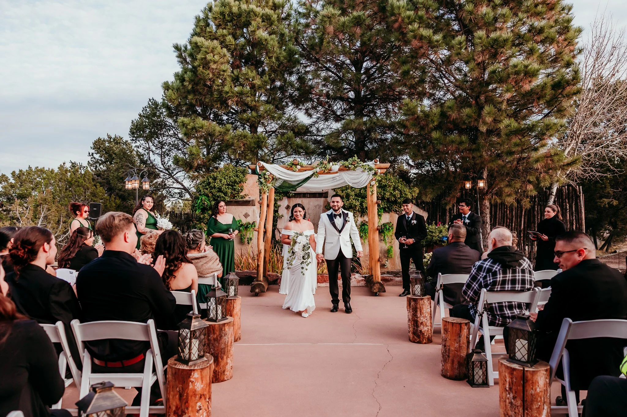 Bride and groom walking down the aisle after their ceremony at Nature Pointe Weddings in Tijeras, New Mexico, surrounded by family and friends.