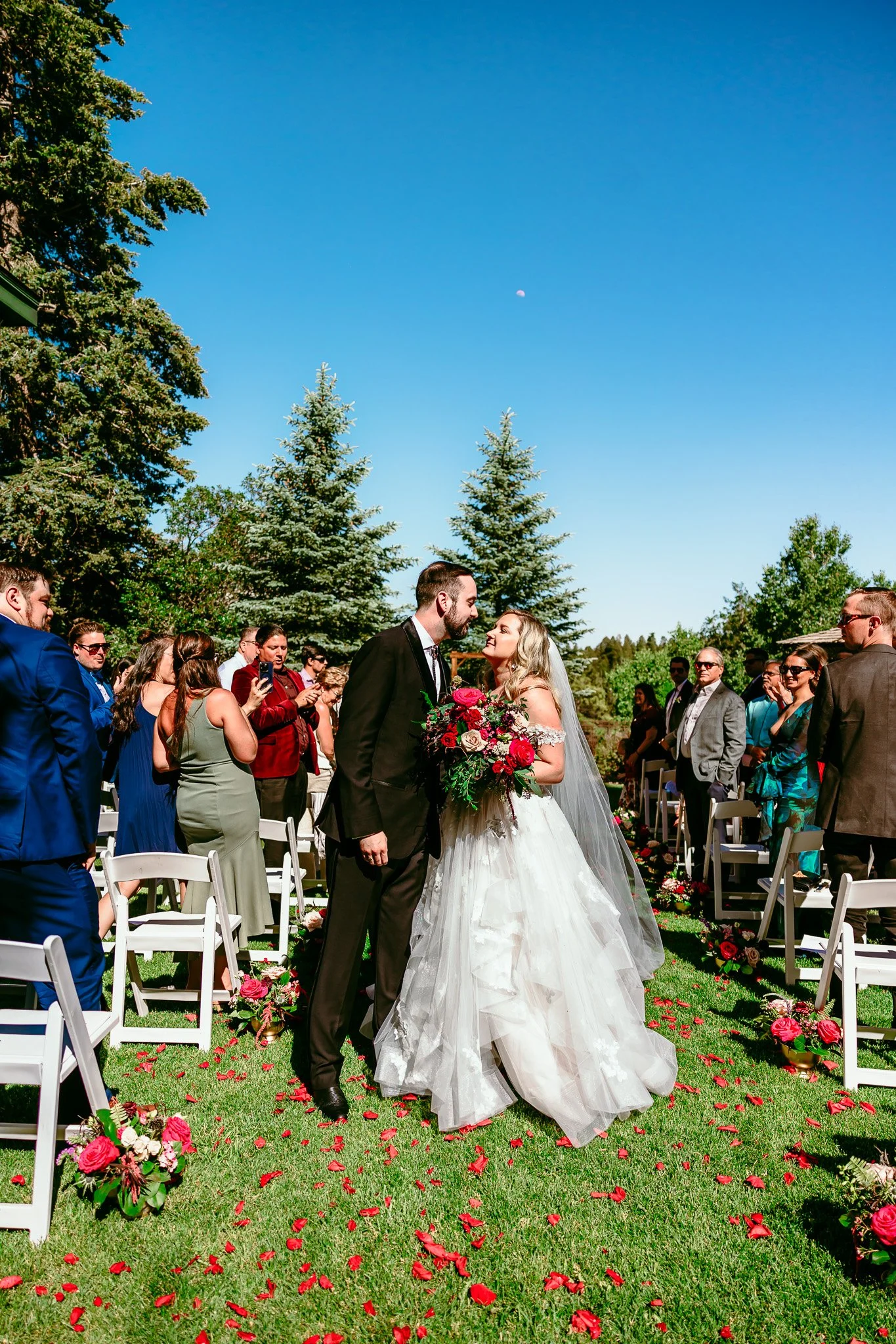 Bride and groom sharing a kiss after their outdoor wedding ceremony at The Lodge Resort in Cloudcroft, New Mexico.