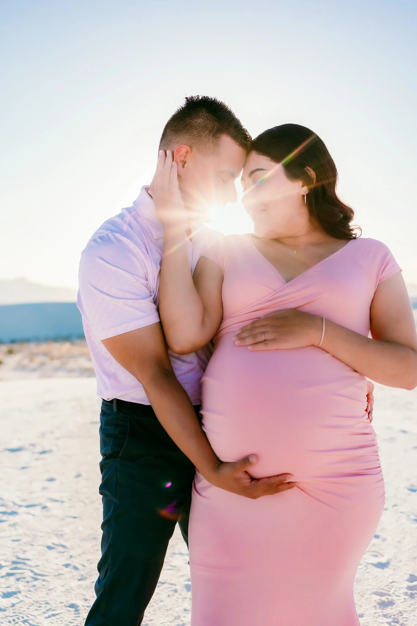 Close-up maternity portrait of expecting parents with a growing baby bump during a White Sands maternity photography session in New Mexico.