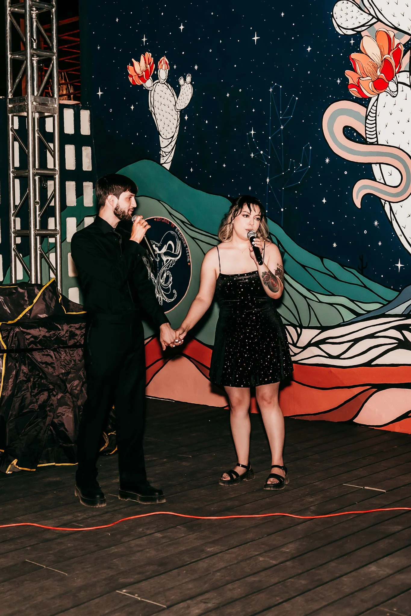 Newlywed couple singing karaoke together on stage at the end of their intimate wedding celebration at The Mystic in Santa Fe, New Mexico.