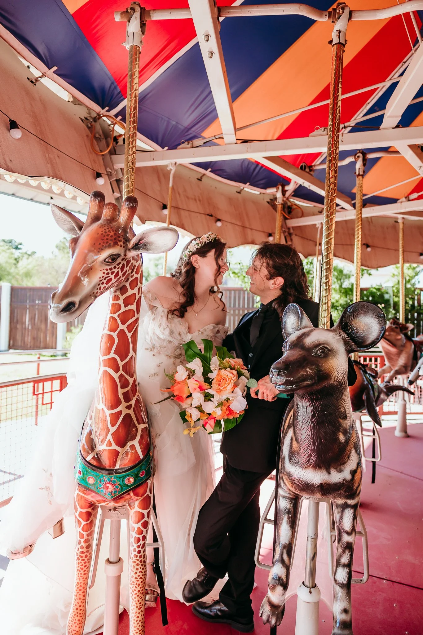Bride and groom gazing into each other's eyes while sitting on the carousel during their El Paso Zoo wedding in El Paso, Texas.