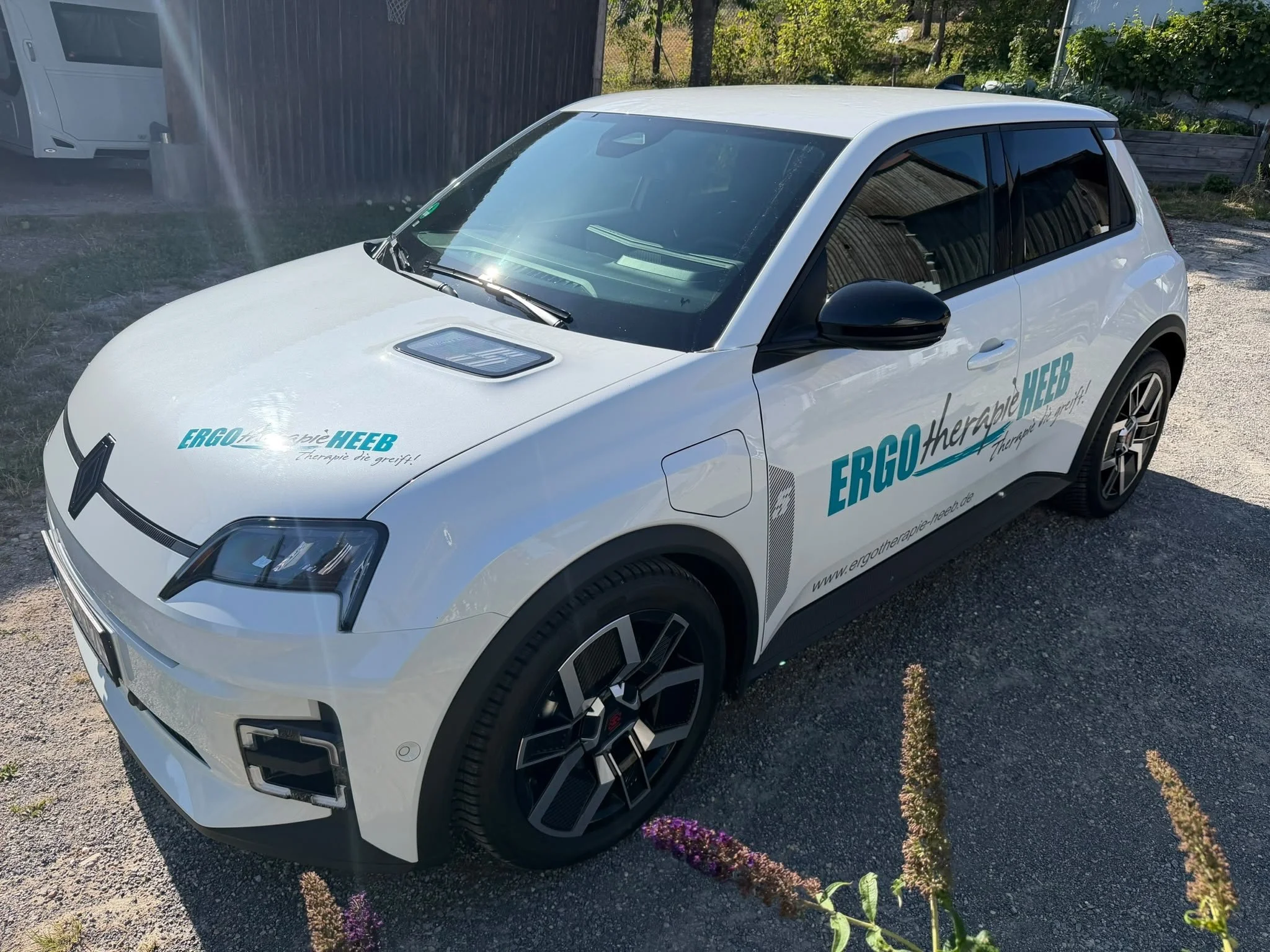 Ein weißer Renault der beschriftet ist mit dem Logo der Ergotherapie Praxis Heeb.