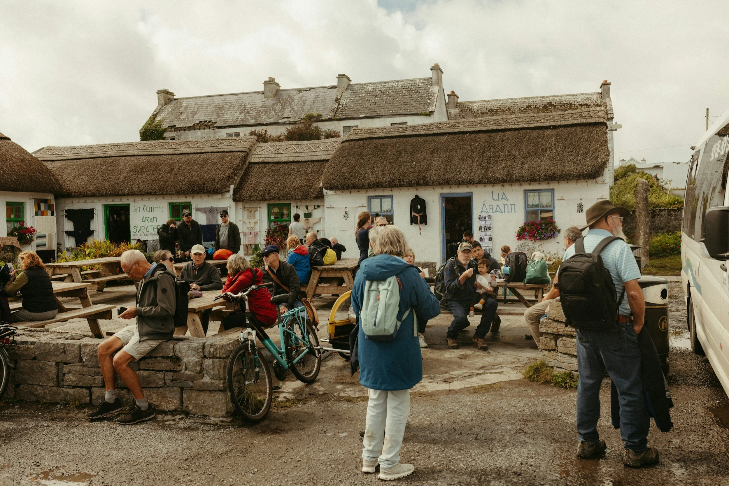 Tourists ourtside an old Irish thatched cottage