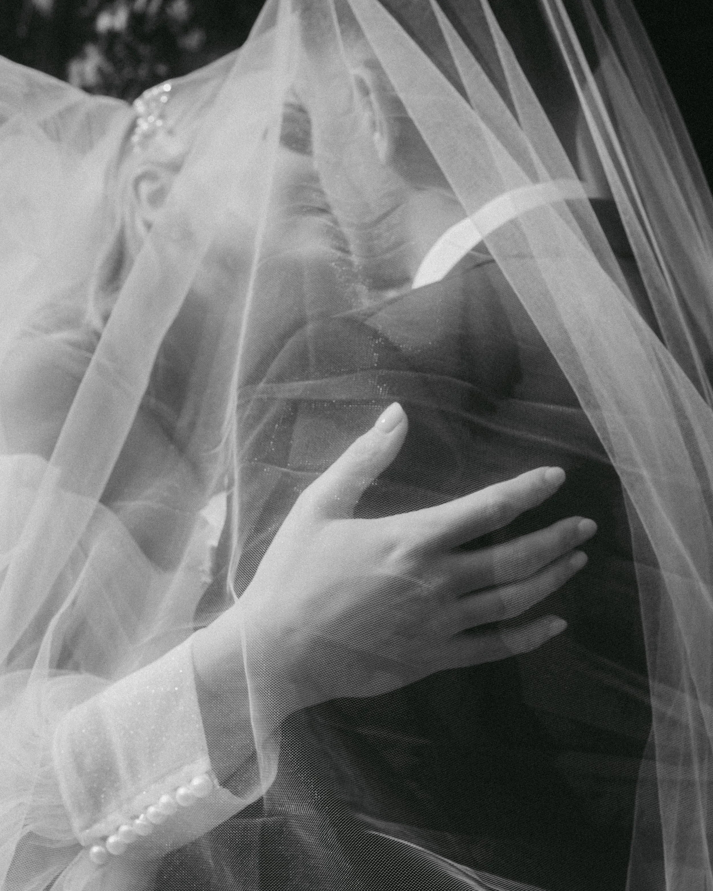 Eine Nahaufnahme einer Frau mit einem Schleier, die eine Hand auf die Brust legt.