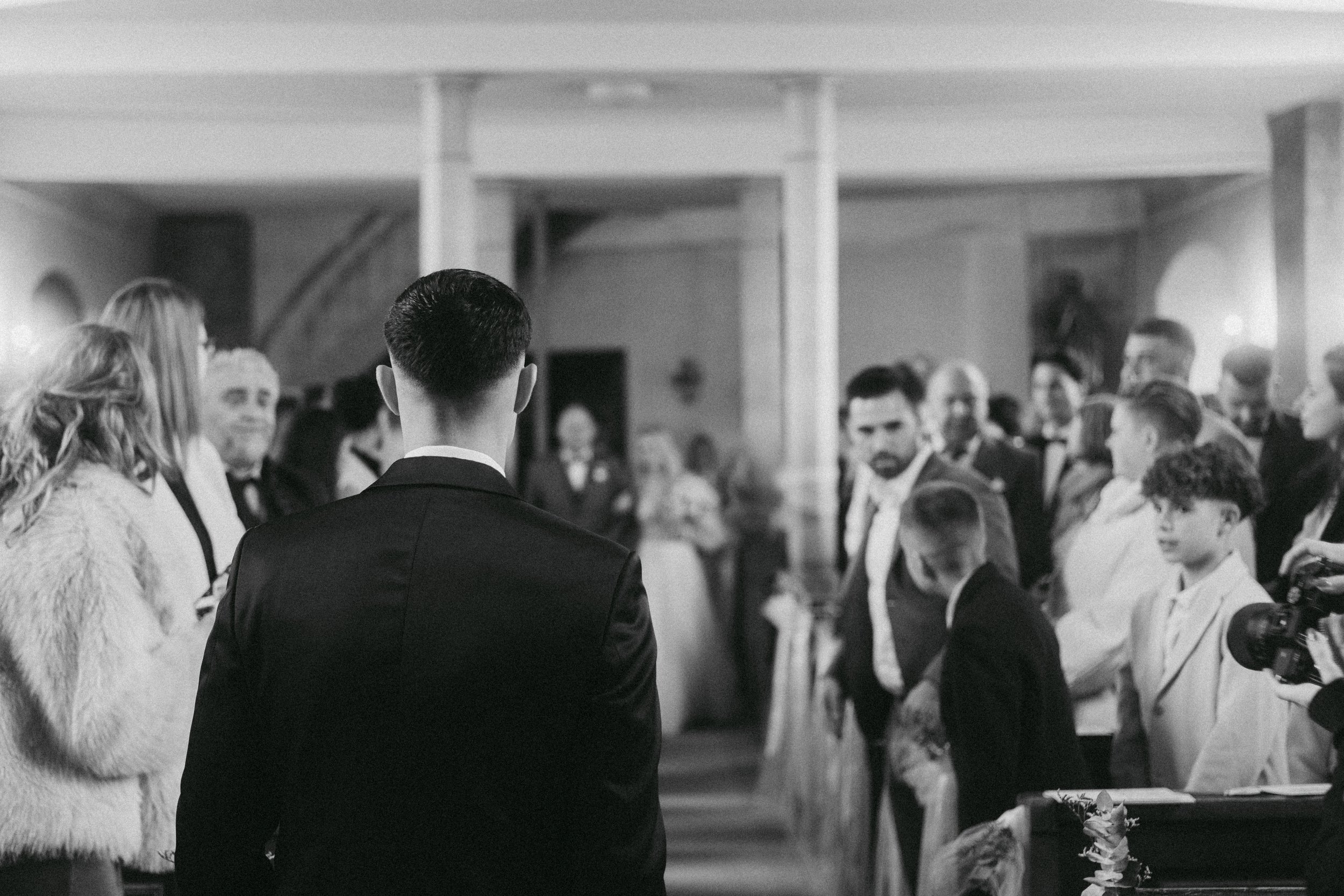 Menschen bei einer formellen Veranstaltung, vermutlich eine Hochzeit, im Schwarz-Weiß-Foto.