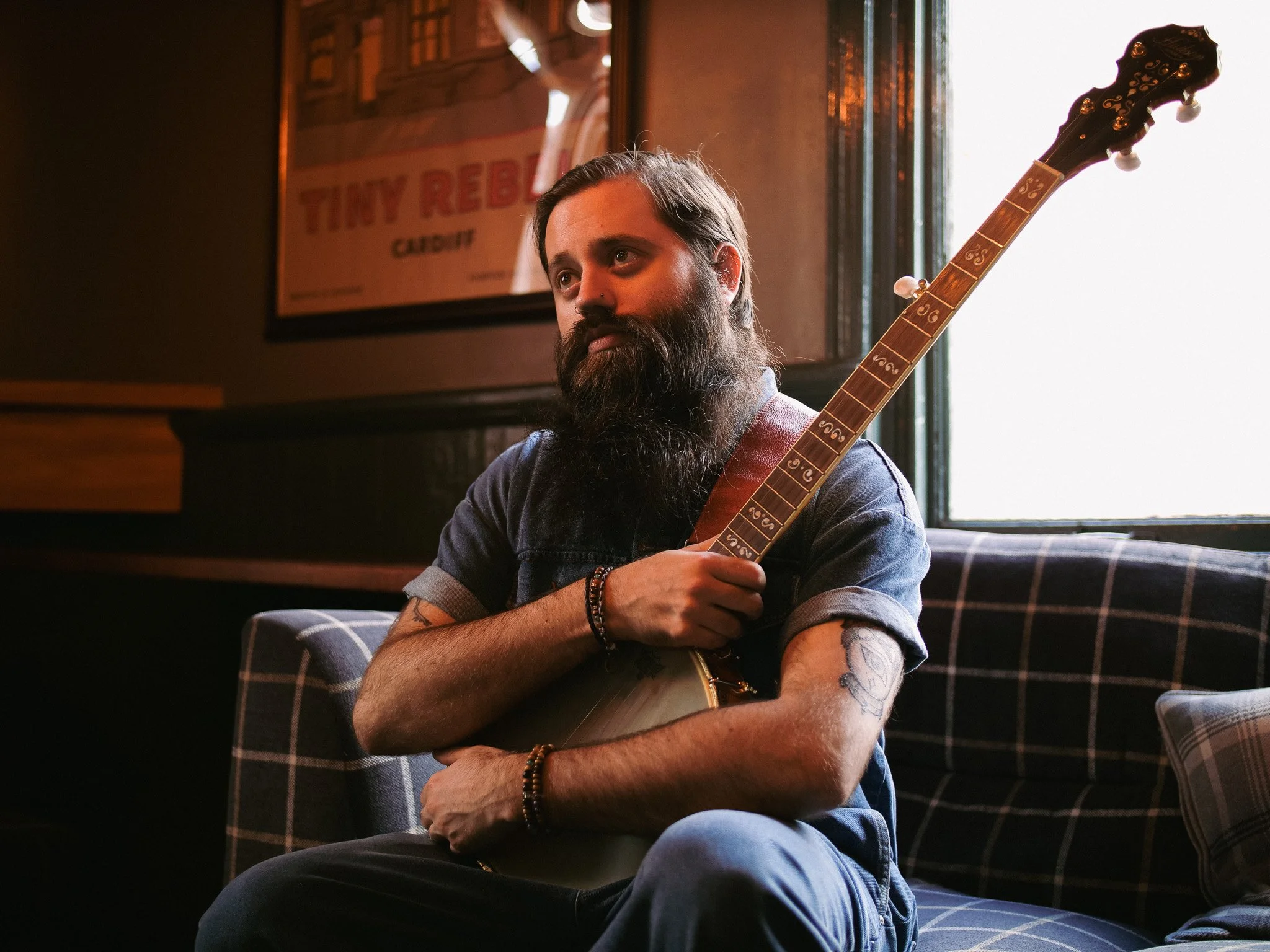 Artist branding photography capturing a musician in an intimate performance environment holding an acoustic guitar.