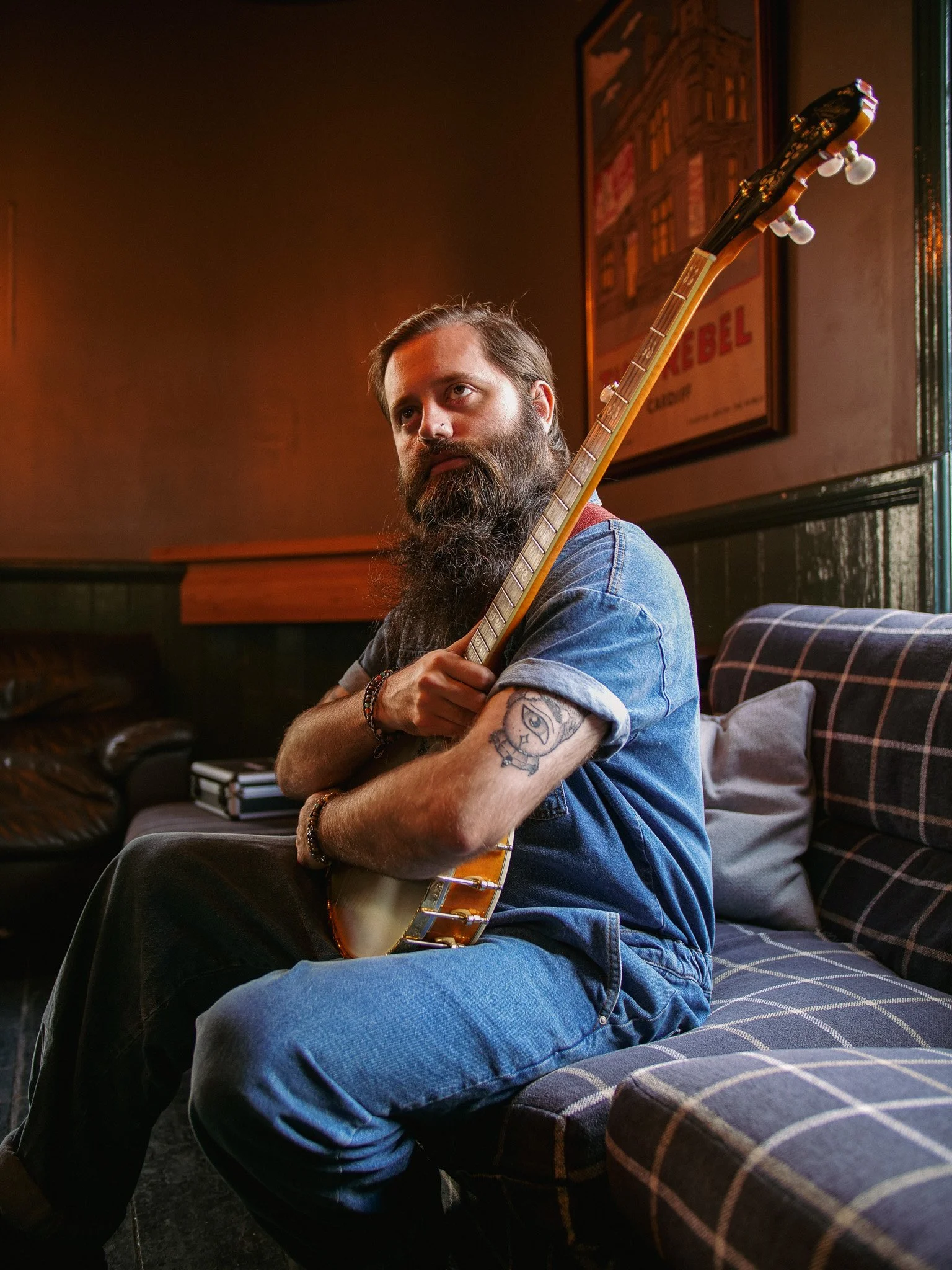 Musician portrait photography capturing an acoustic artist in a warm, cinematic setting.