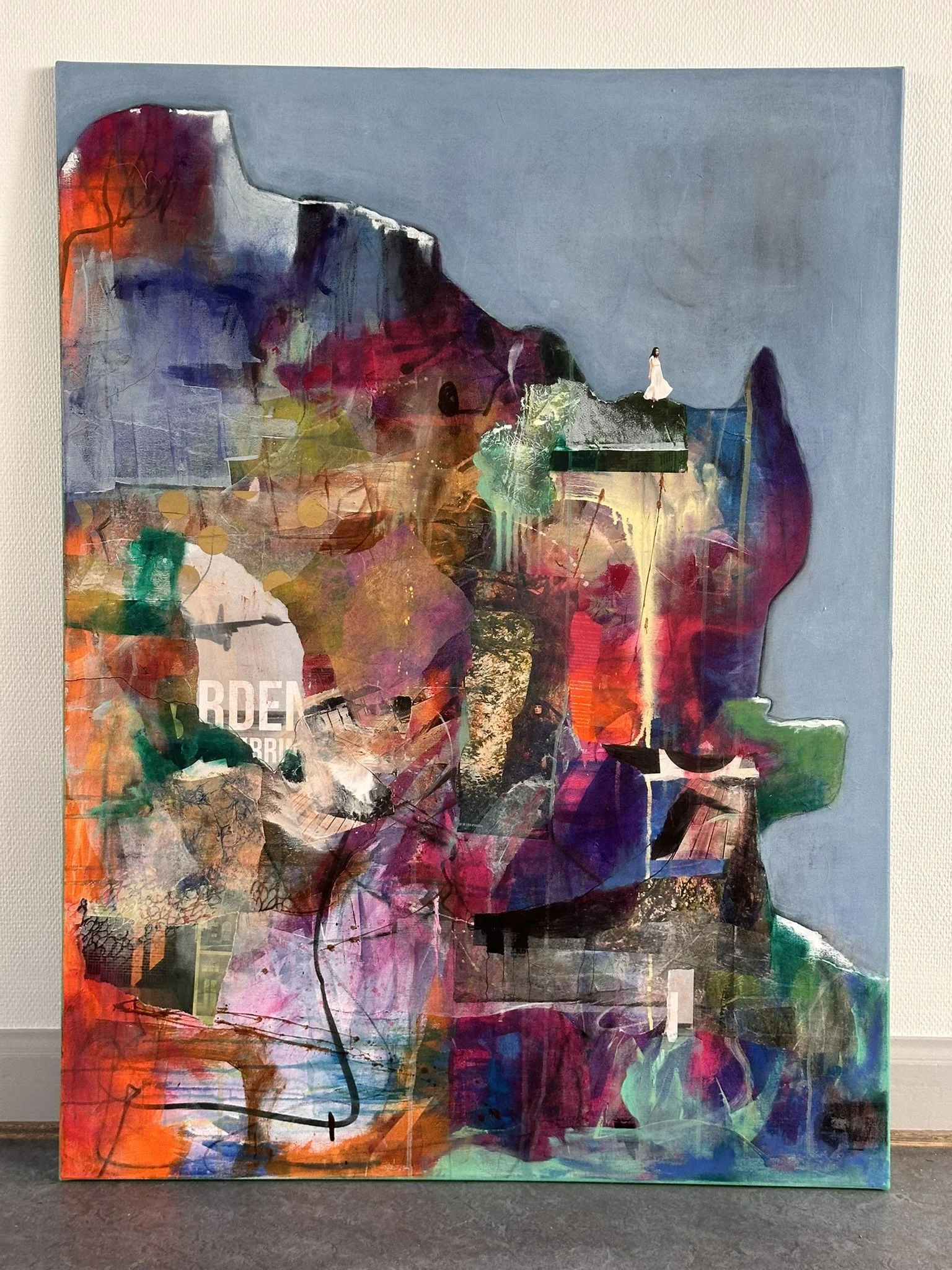 Abstrakt maleri med collage-elementer og en kvinde i midten, omgivet af farverige og teksturerede områder.