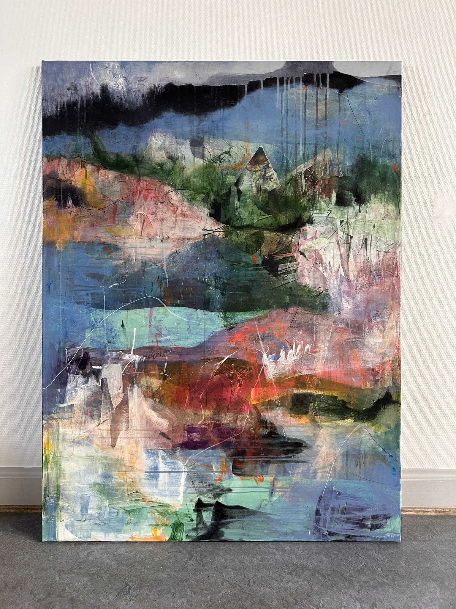 Abstrakt maleri med collage-elementer og en kvinde i midten, omgivet af farverige og teksturerede områder.