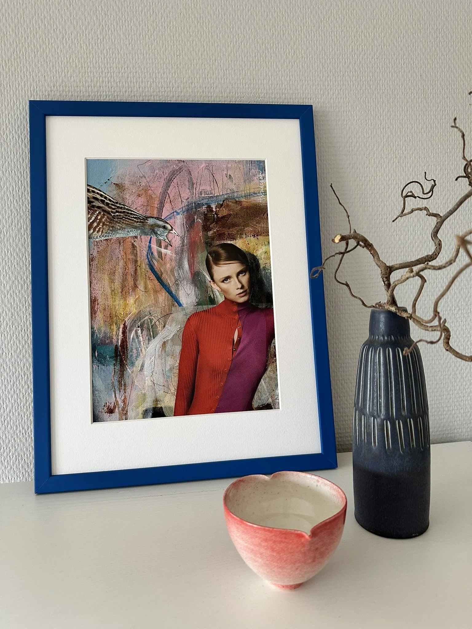 Collage i blå ramme, kvinde og fugl med abstrakt baggrund