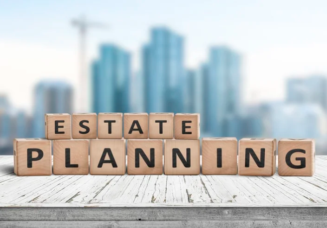 Wooden blocks spelling out 'ESTATE PLANNING' on a wooden surface with a cityscape background.