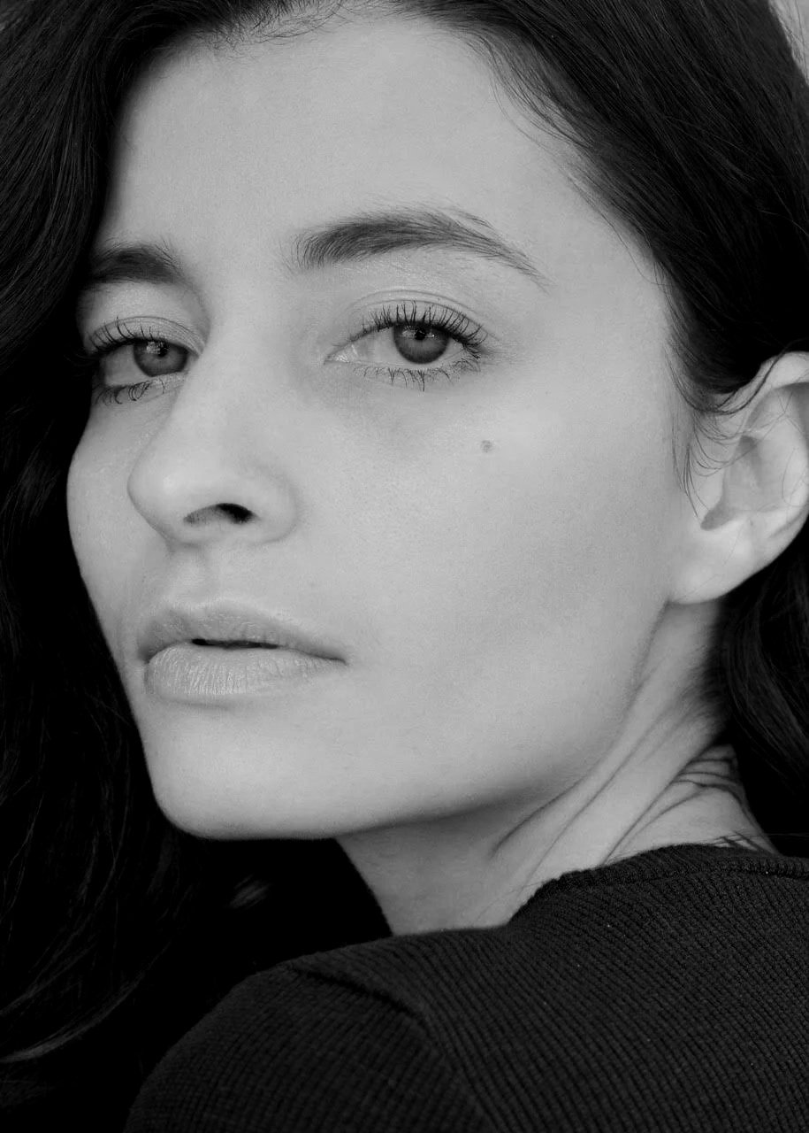 Primer plano de rostro de mujer con cabello oscuro, mirada mirando al frente, en blanco y negro.