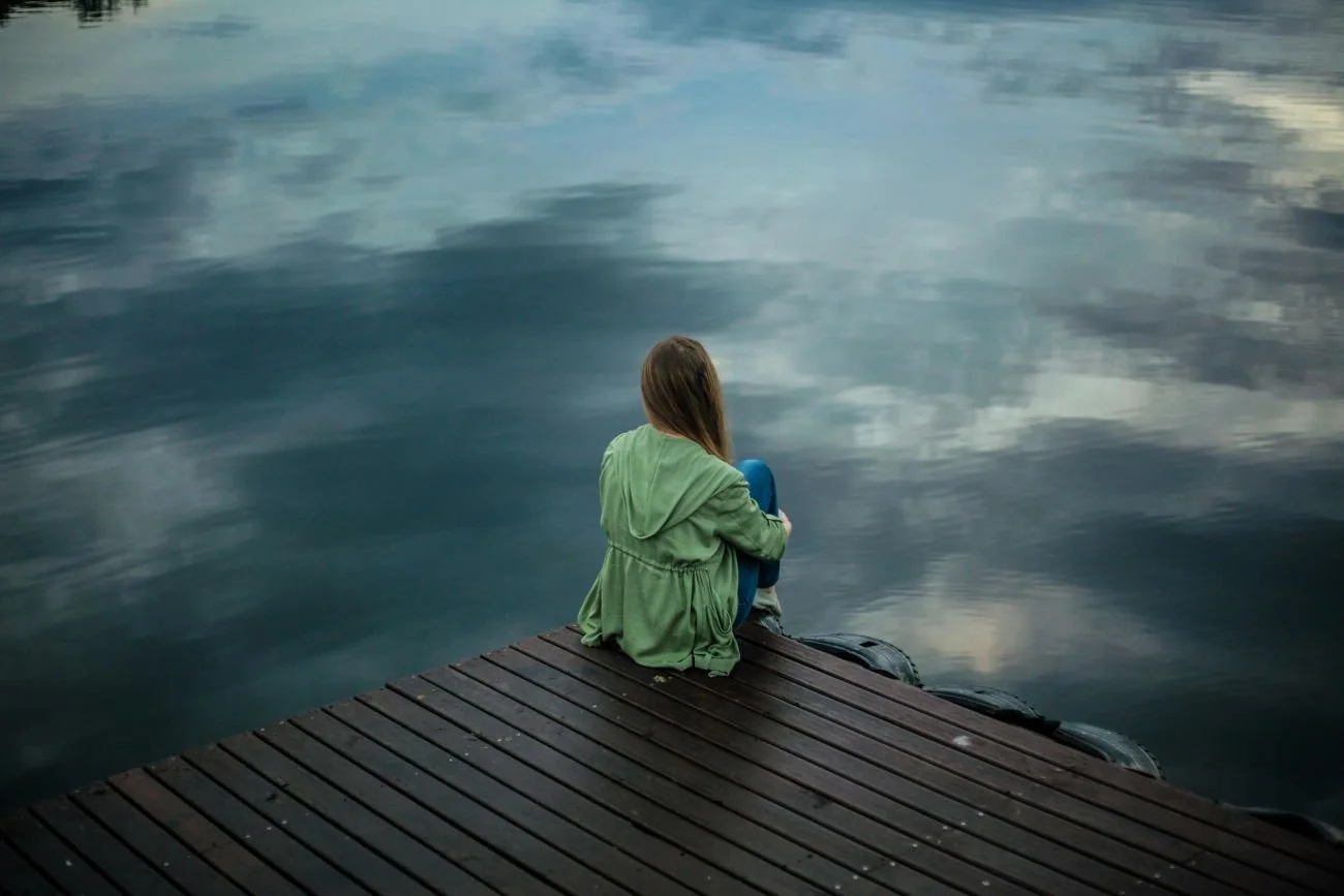 woman depressed sitting on dock
