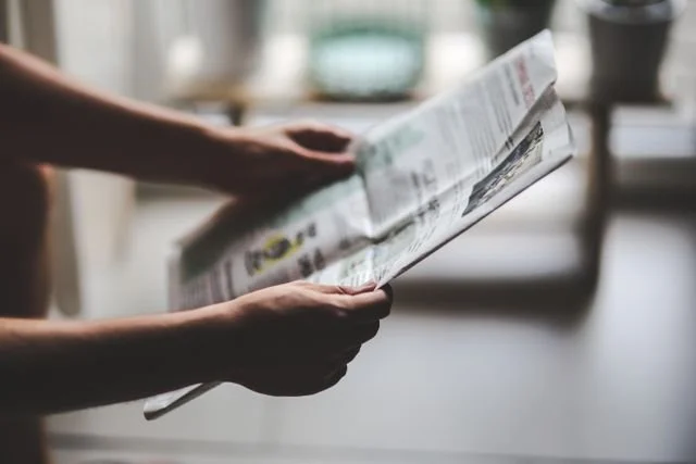 holding a newspaper