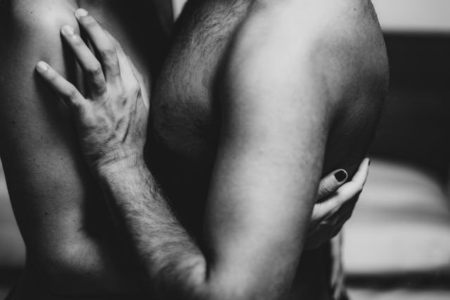 man and woman embrace with no shirt on.