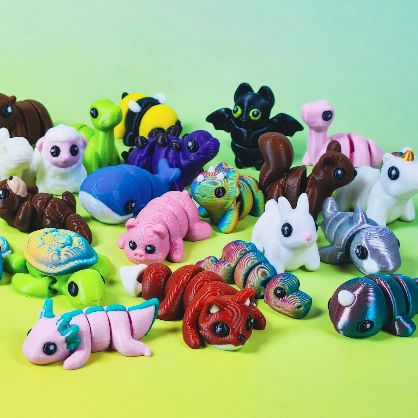 Colorful toy animals and creatures resembling dinosaurs, unicorns, and mythical animals on a bright green surface.