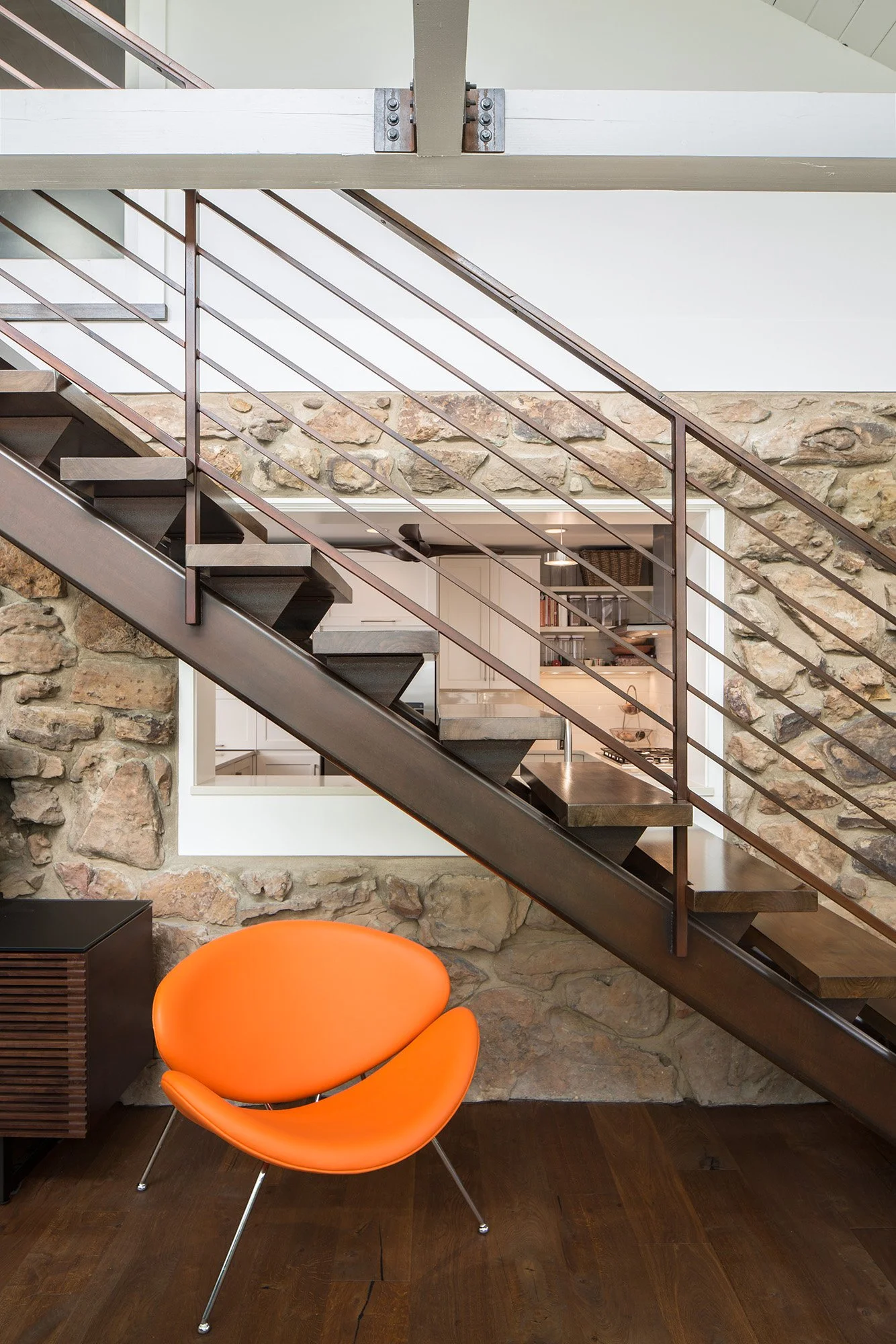 Steel floating stair suspended beside the original stone wall, introducing a new circulation path through the renovated Anabranch House.